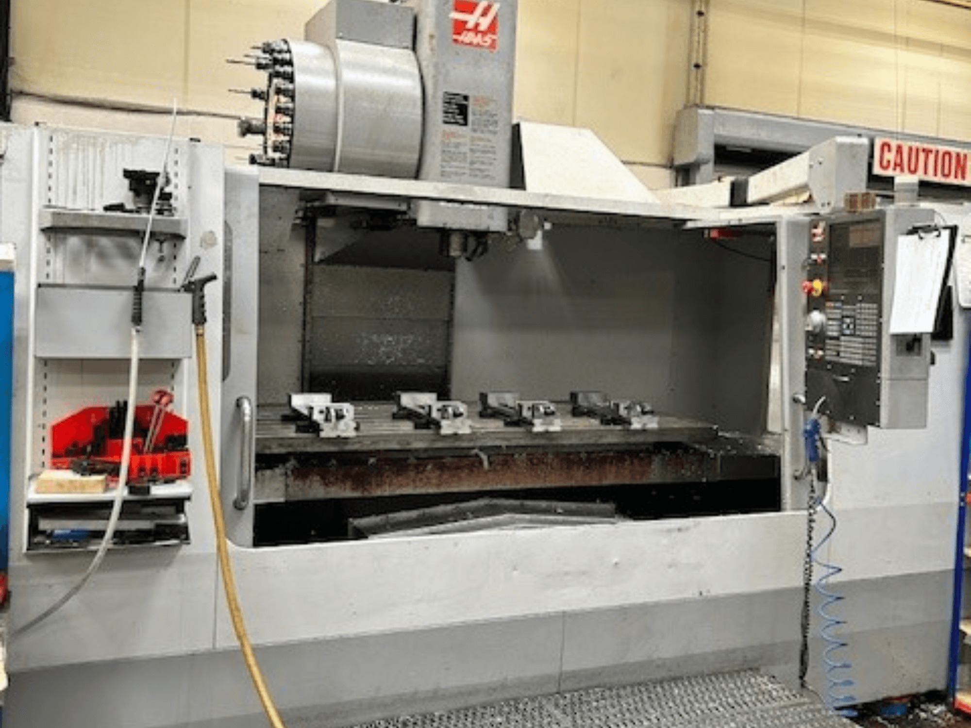 HAAS VF-9/40HE vertical machining center, front view, with tool holder and accessories visible on the side.