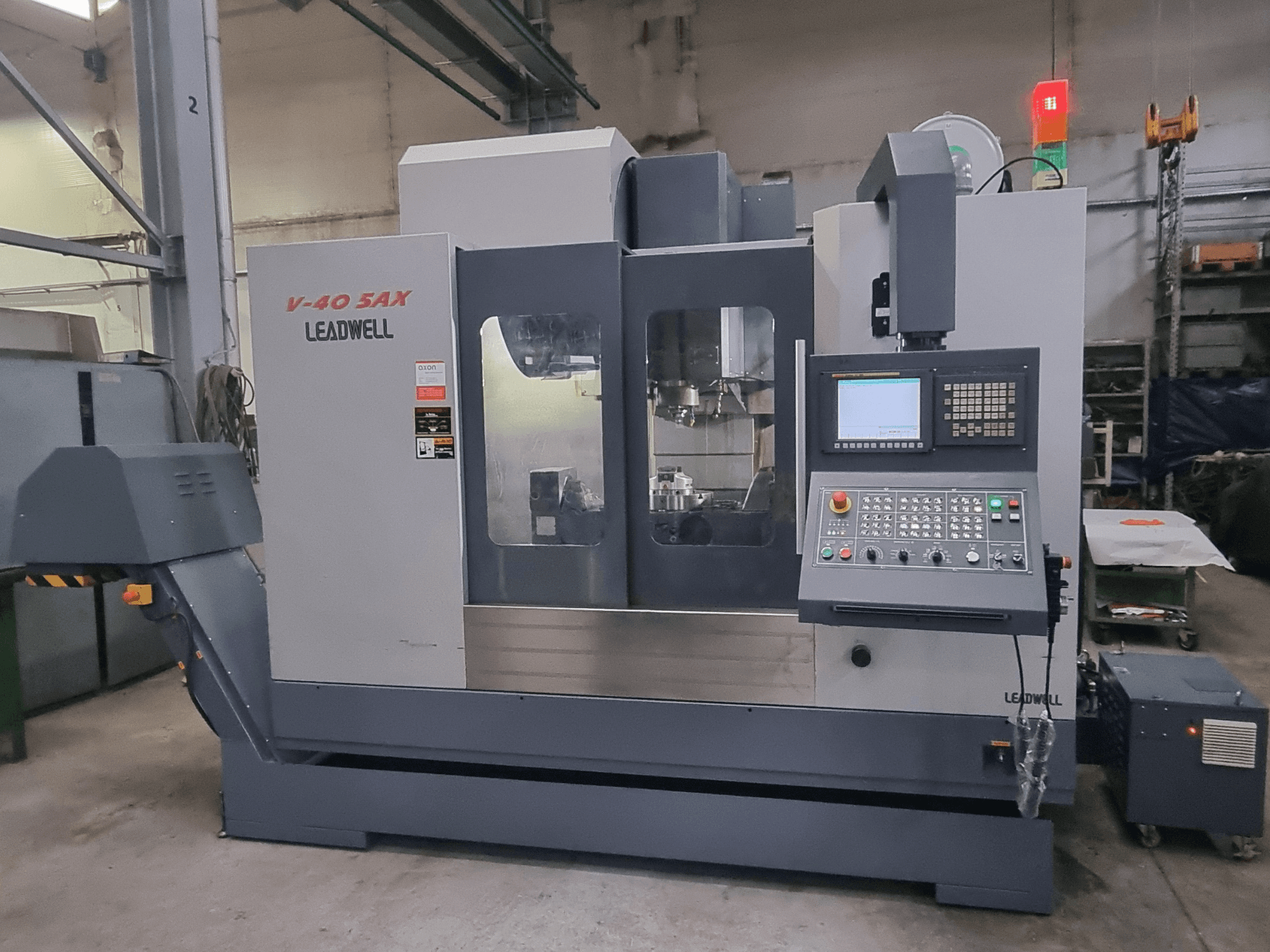Leadwell V40 5AX vertical machining center, front view, showcasing control panel and machining area with safety lights.