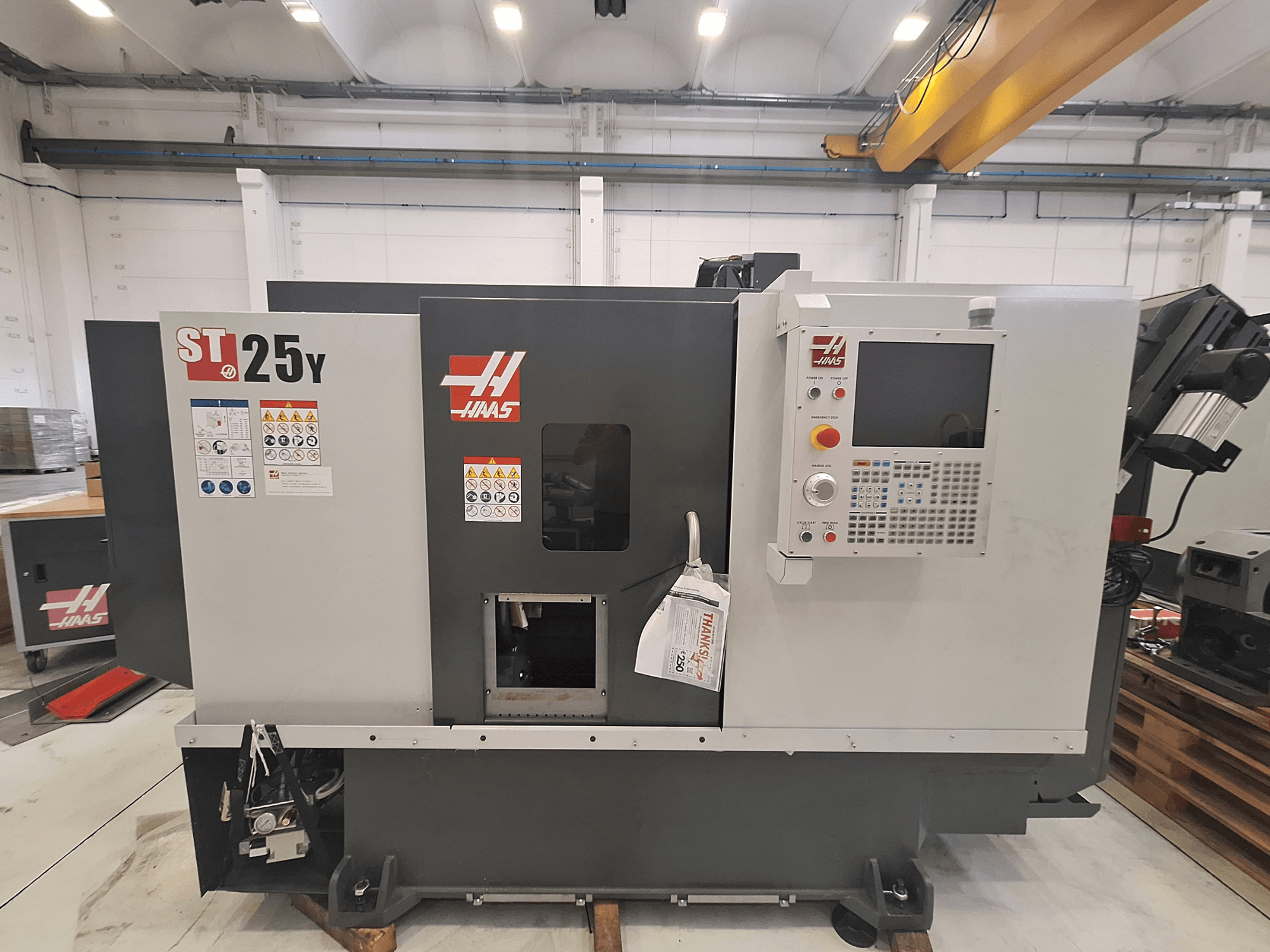 Haas ST-25Y horizontal turning machine, front view, features control panel and safety labels. Ideal for precision machining.