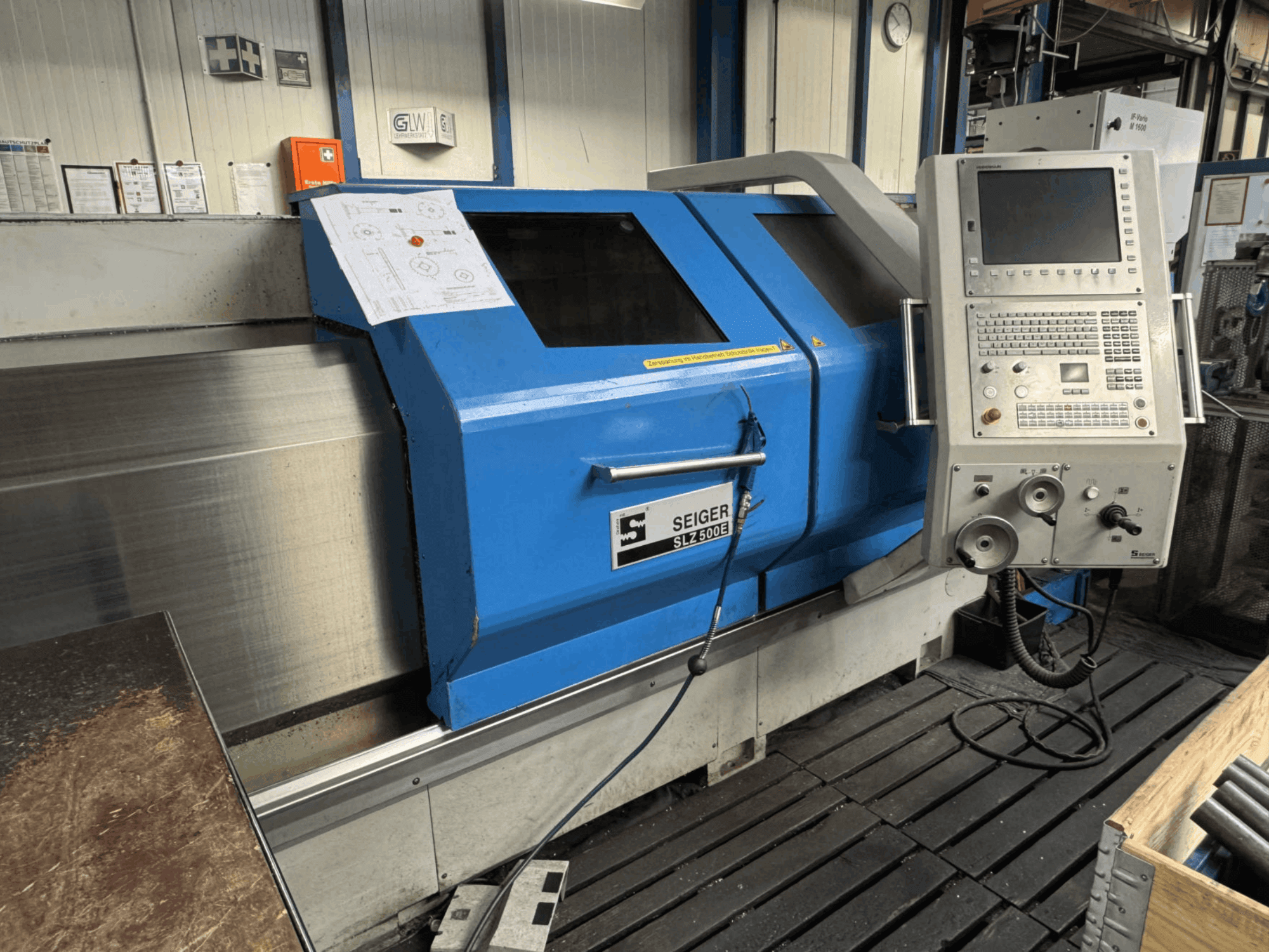 Front view of SEIGER SLZ 500E horizontal turning machine with control panel, blue exterior, and blueprint displayed.
