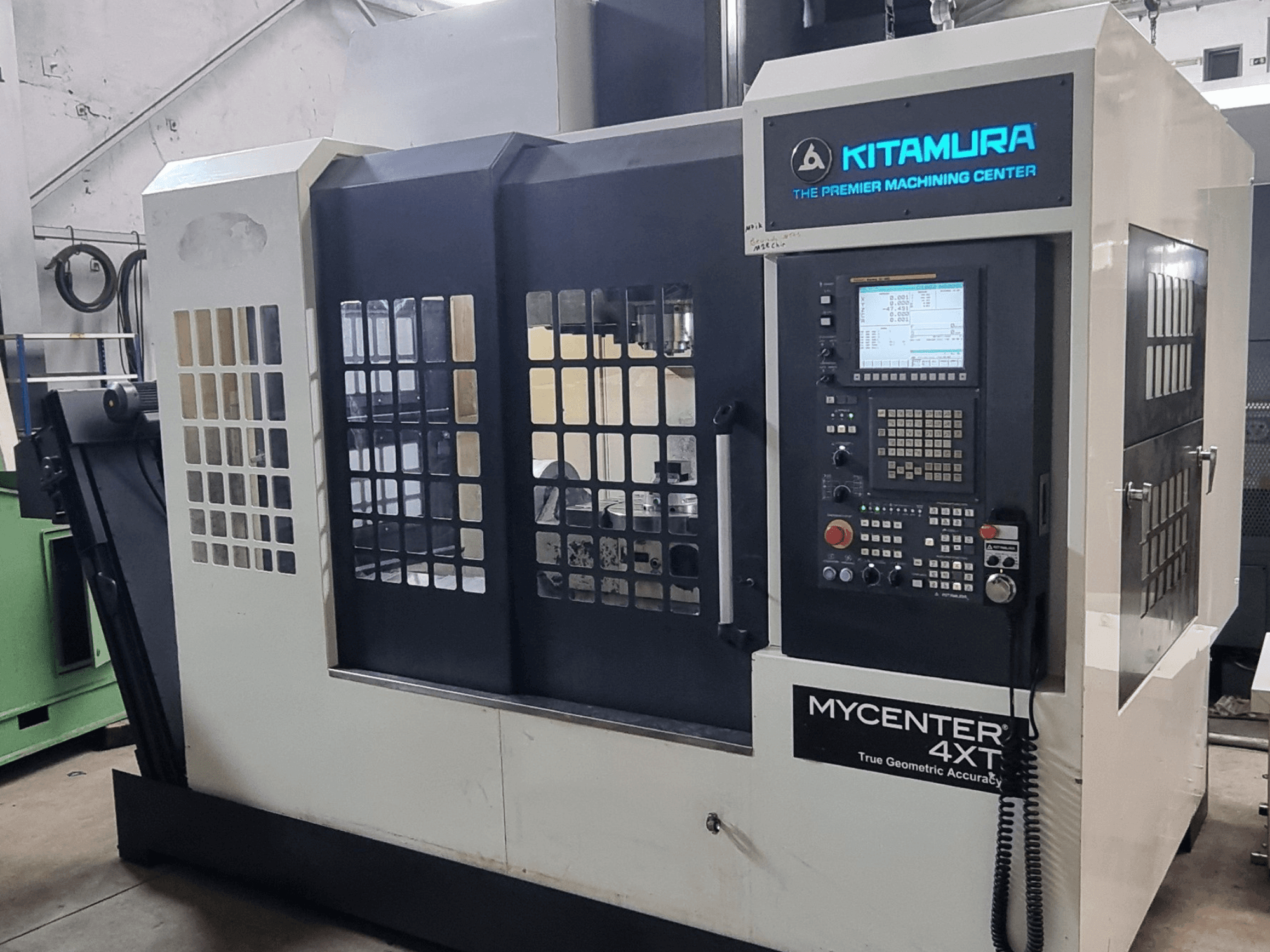 Alt text: Kitamura MYCENTER 4XT vertical machining center, front view, showcasing control panel and machine details in a workshop setting.