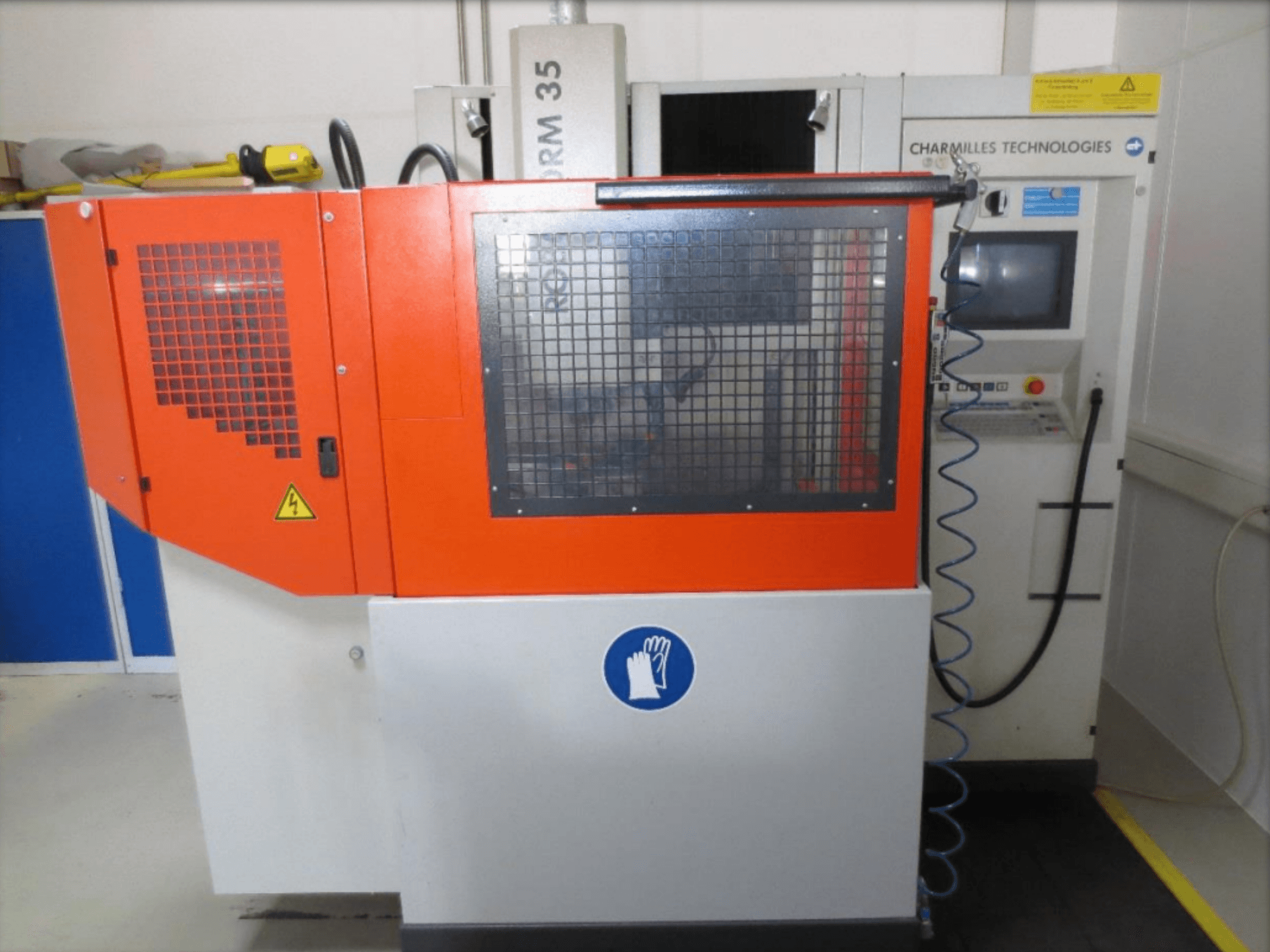 Front view of CHARMILLES Roboform 35 die-sinking EDM machine with red panels and control interface visible.