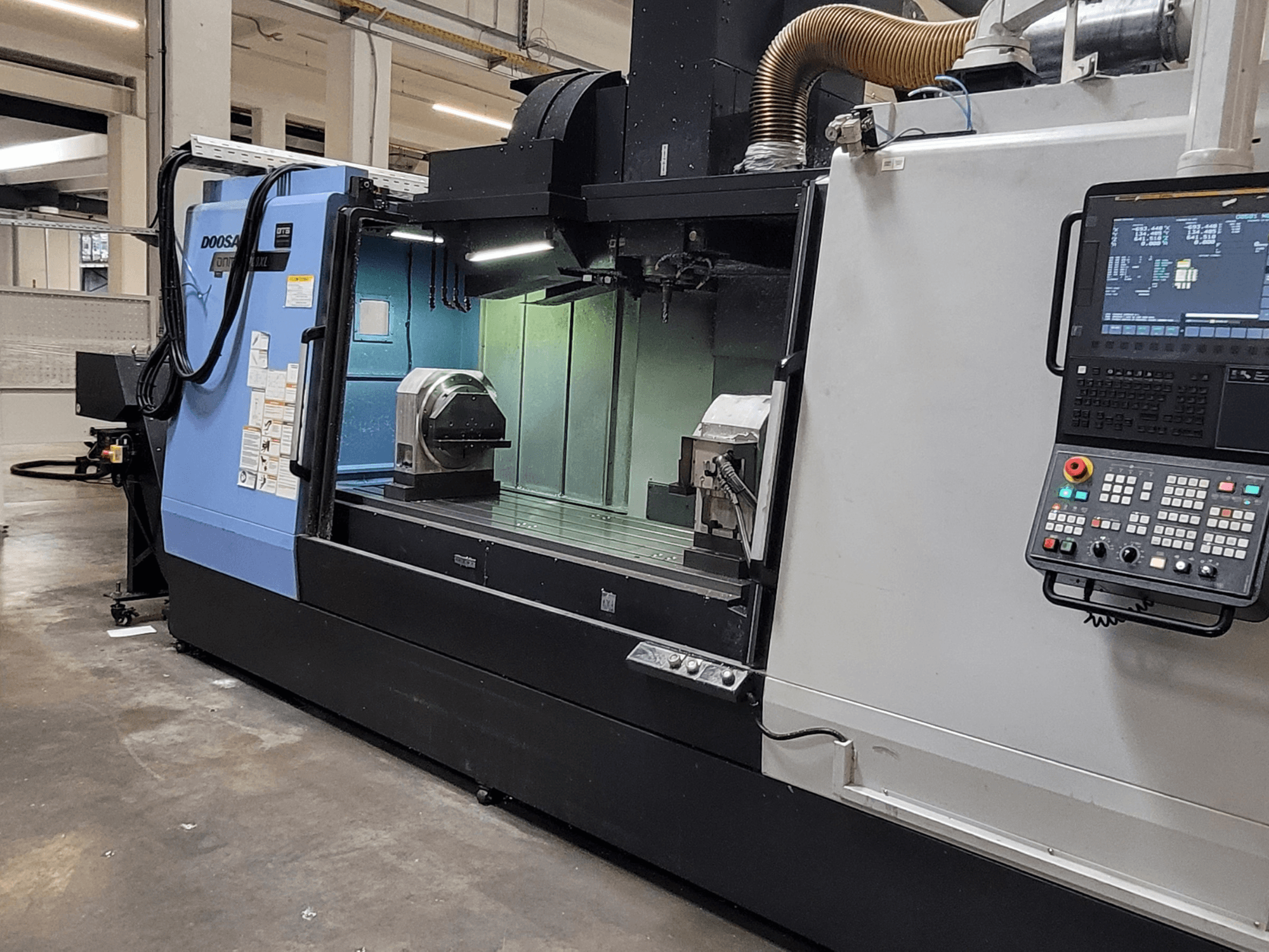 DOOSAN DNM 6700 XL vertical machining centre, front view showing control panel, worktable, and machining area.