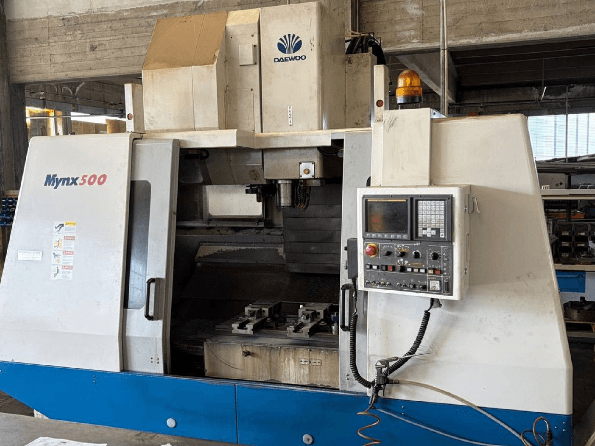 DAEWOO Mynx 500 vertical machining centre shown from the front, featuring a control panel and tool holder inside.