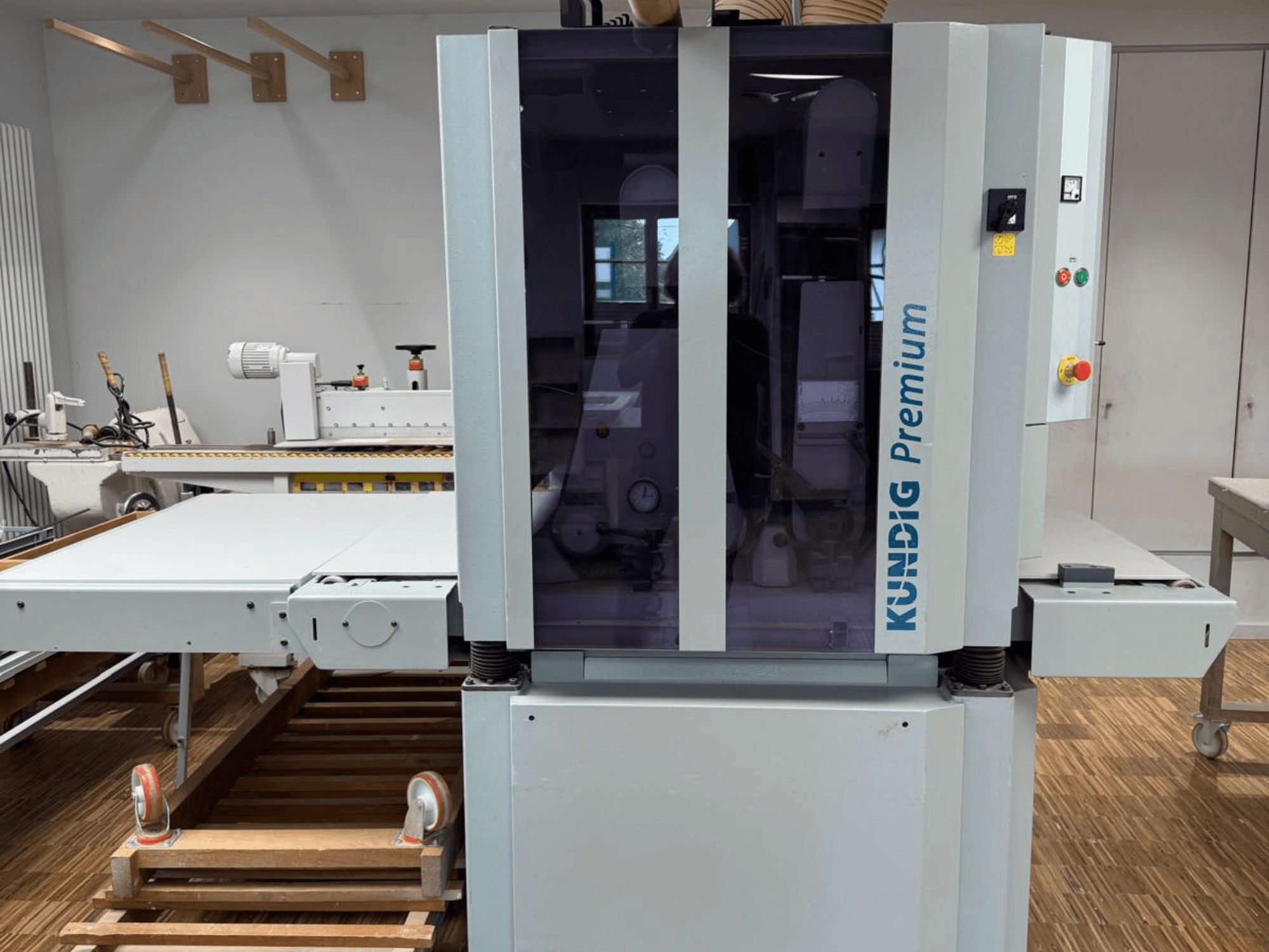 Kundig Premium 2-1100-RP belt sander in front view with control panel and large glass enclosure for visibility.