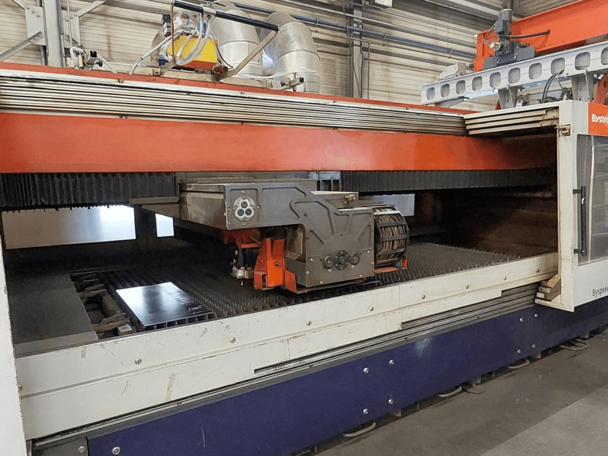 Bystronic BySpeed 3015 CO2 laser cutting machine, front view showing cutting head and metal sheet on the cutting bed.