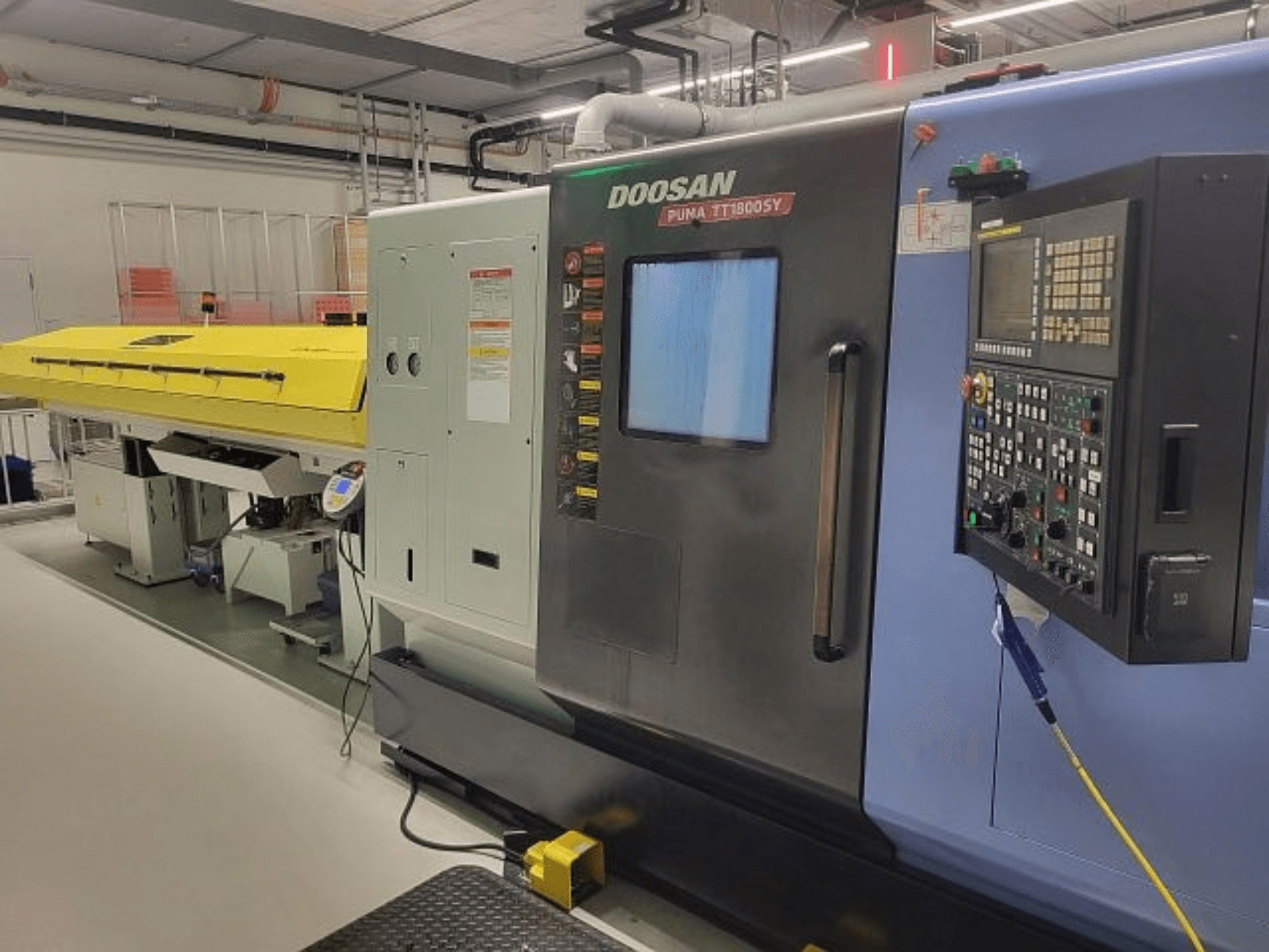 DOOSAN PUMA TT 1800 SY turn-mill centre, front view with control panel and yellow cover, industrial setting.