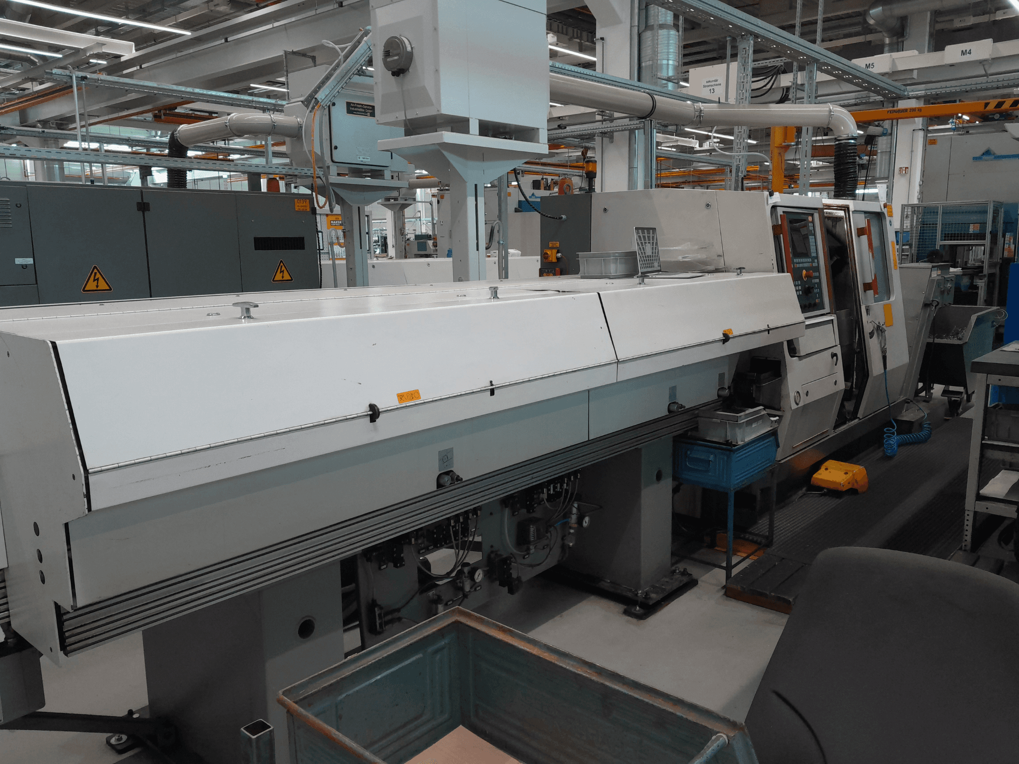 TRAUB TNA 300 horizontal turning machine, front view; features a sleek design, control panel, and operational workspace.
