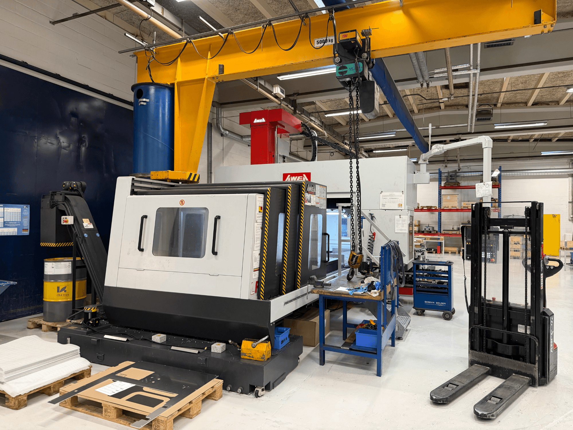 Gantry milling machine AWEA LP3016YF, front view, with tools, blue tank, and workspace in background.