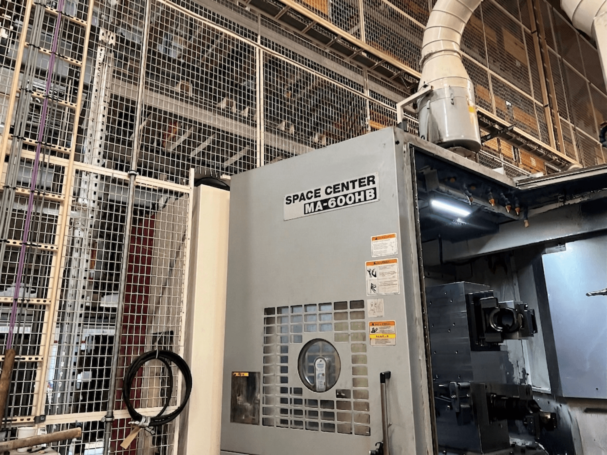 Okuma MA-600HB horizontal machining center, front view, with operational panel and coolant nozzles visible.