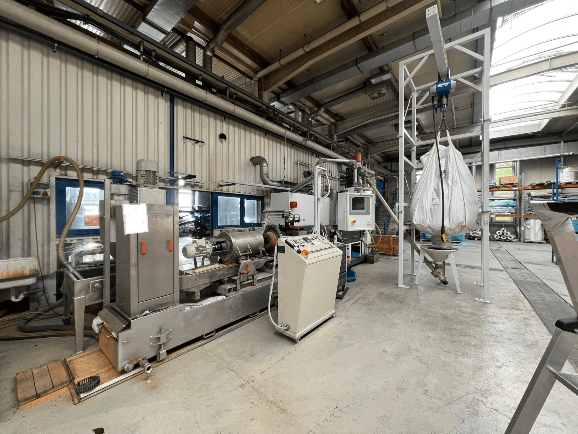 Front view of the FILTEC GRP 350 plastic processing machine in an industrial setting, featuring controls and feeding system.
