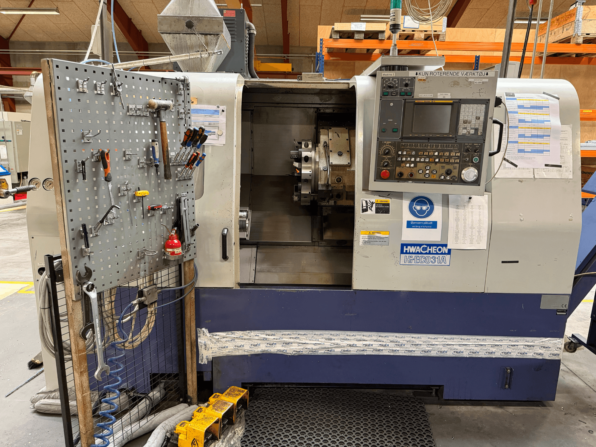 HWACHEON HiEco-31A horizontal turning machine with control panel, tools on side, and clear visibility of the machine's interior.