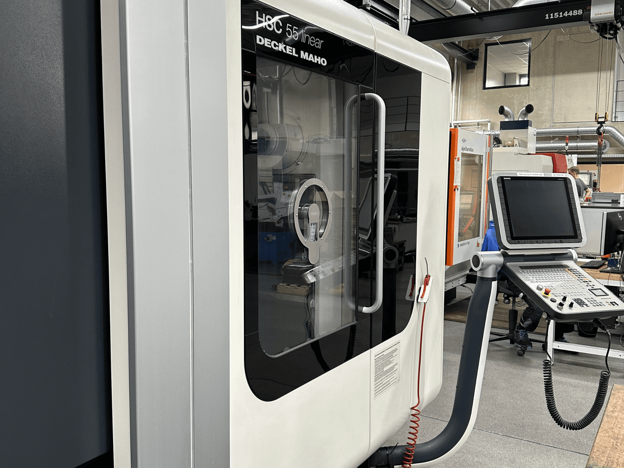 Deckel Maho HSC 55 linear milling machine viewed from the front, featuring a control panel and transparent panel for viewing interior.
