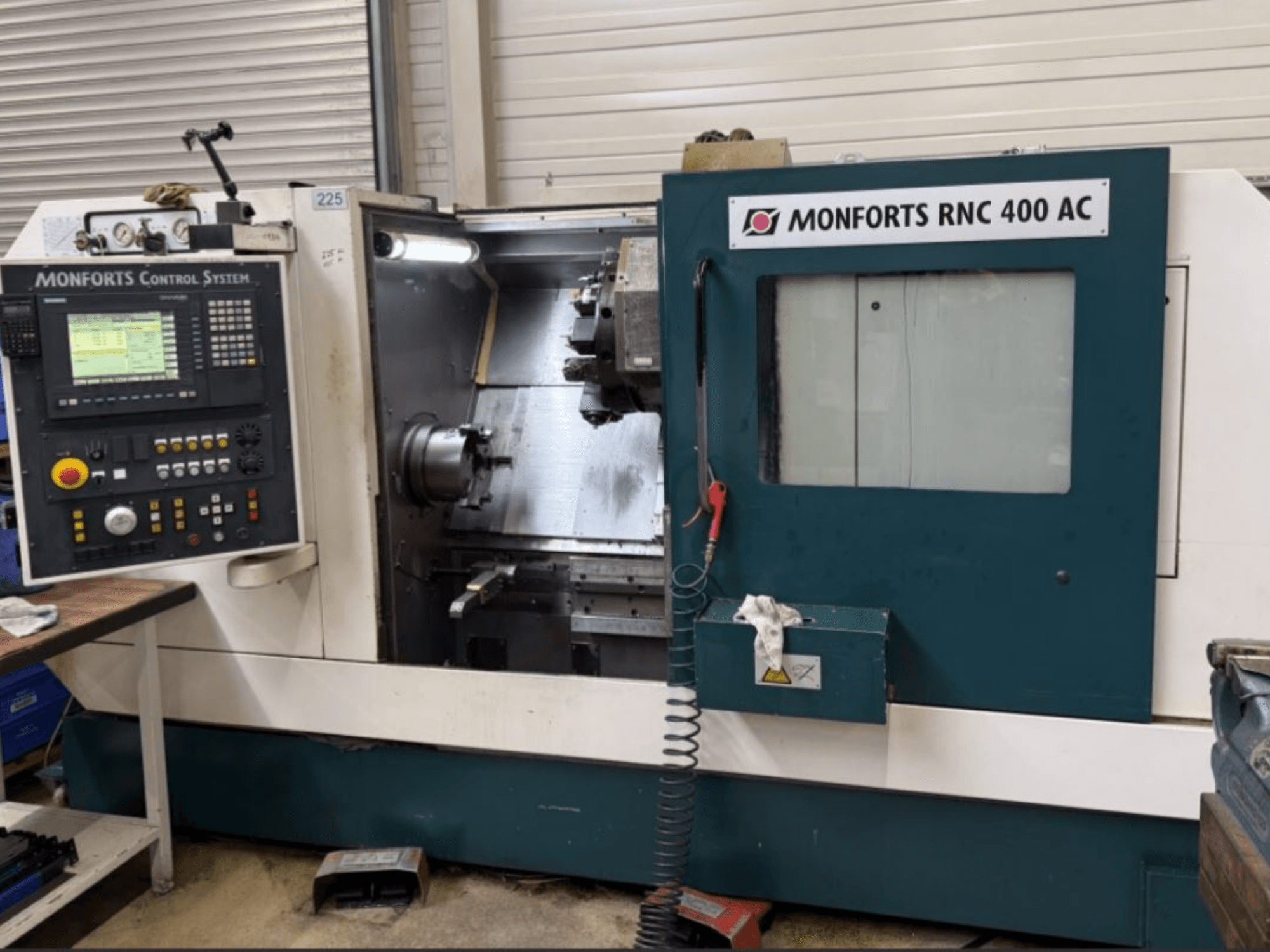 Monforts RNC 400 AC horizontal turning machine, front view, showcasing control panel and machining area with visible tools.