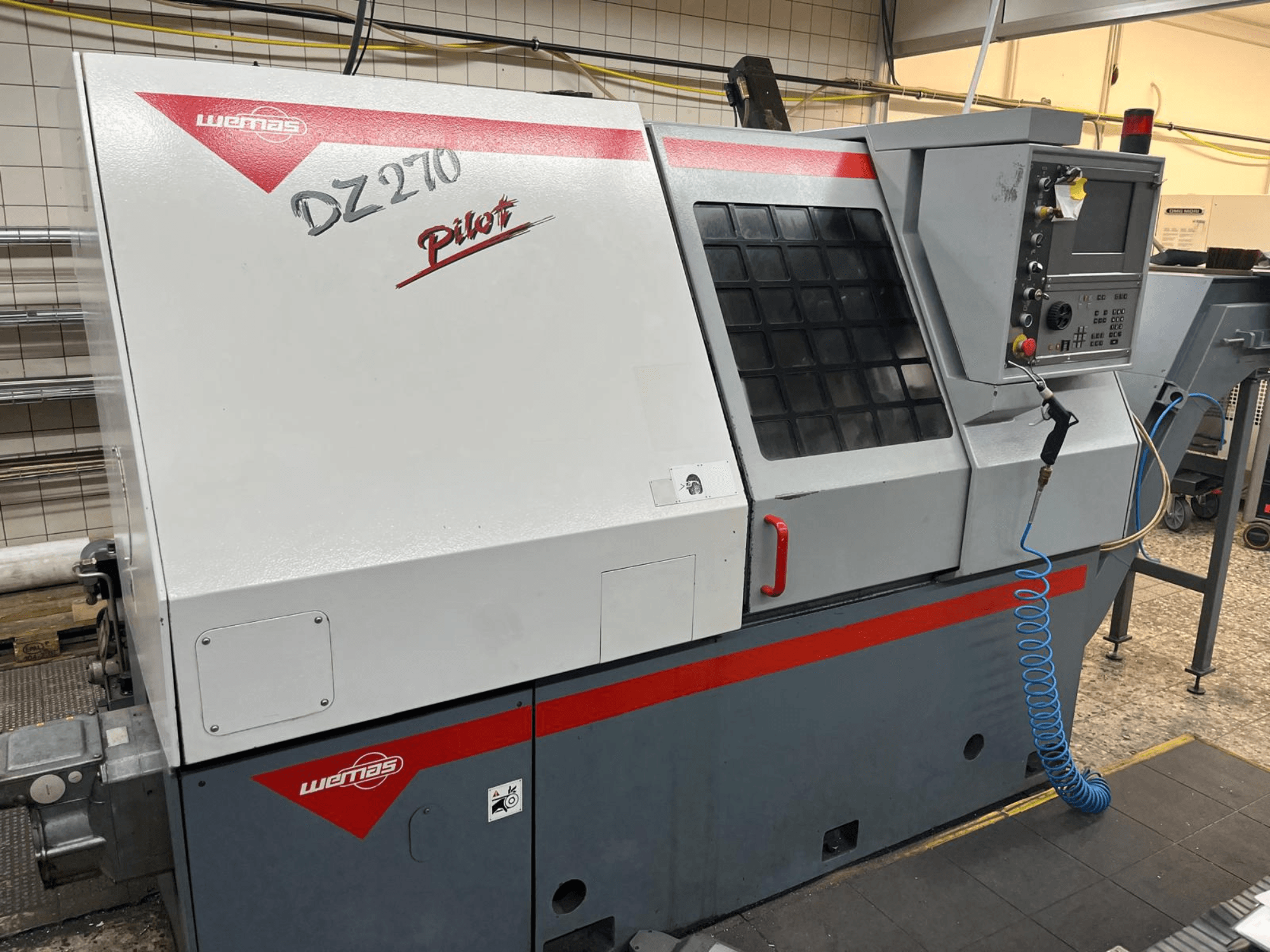 WEMAS DZ 270 horizontal turning machine from a front view, featuring a control panel, ventilation, and safety features.