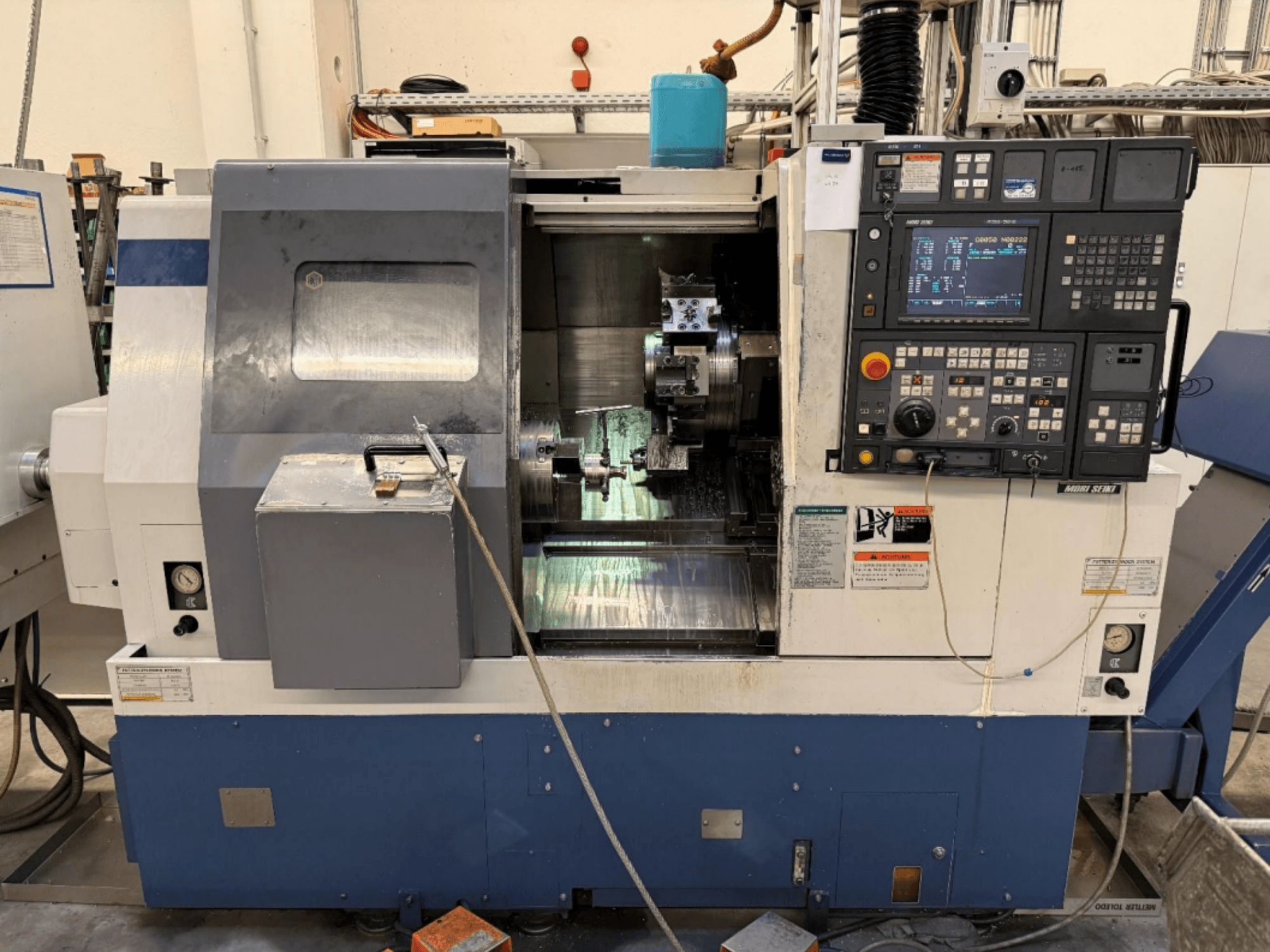 MORI SEIKI SL-250ASMC Turn-Mill Centre, front view showing control panel and workpiece chuck in operation.