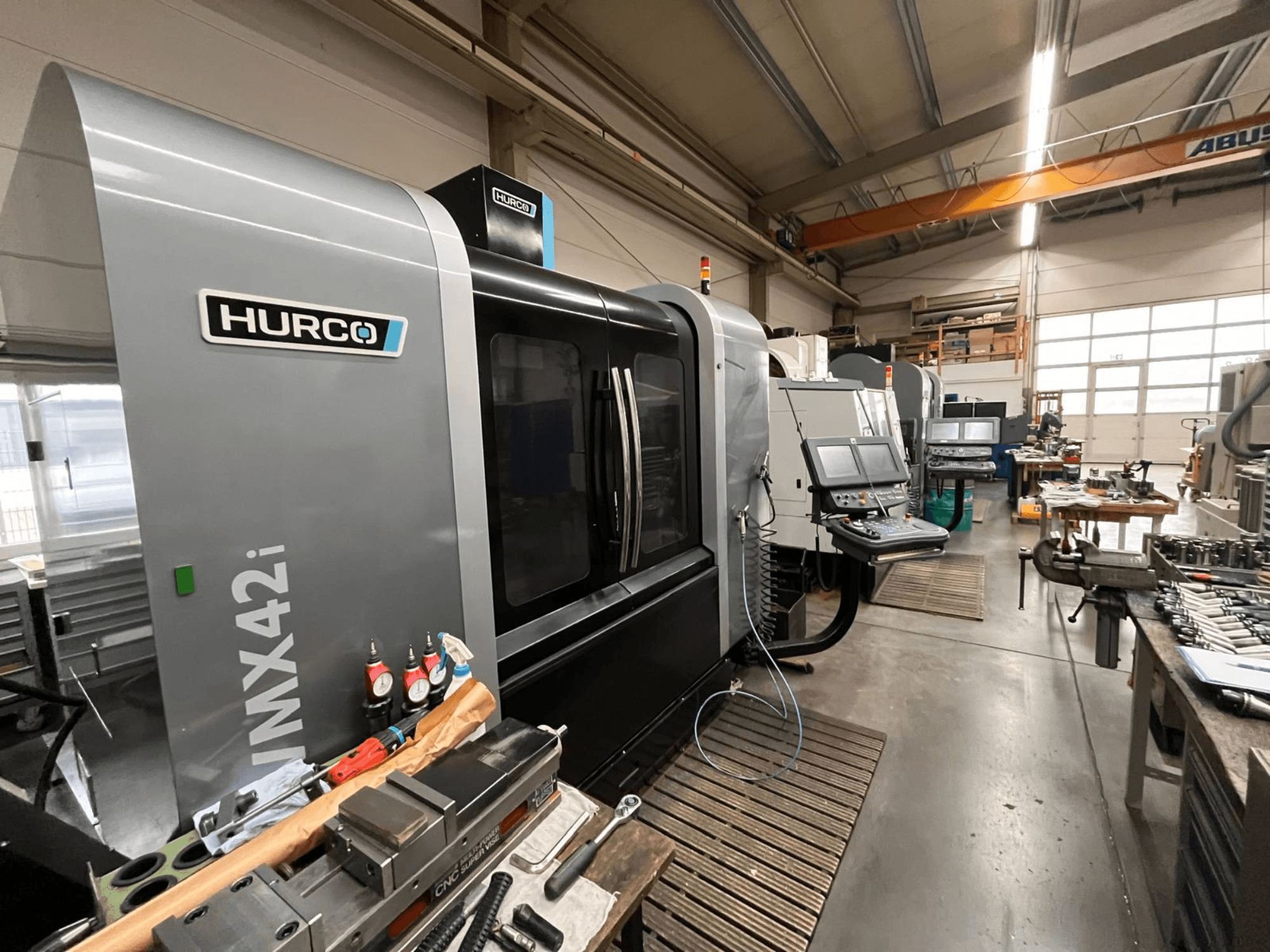Hurco VMX42i CNC machine in a workshop, front view. Features control panel, gray body, and industrial surroundings.