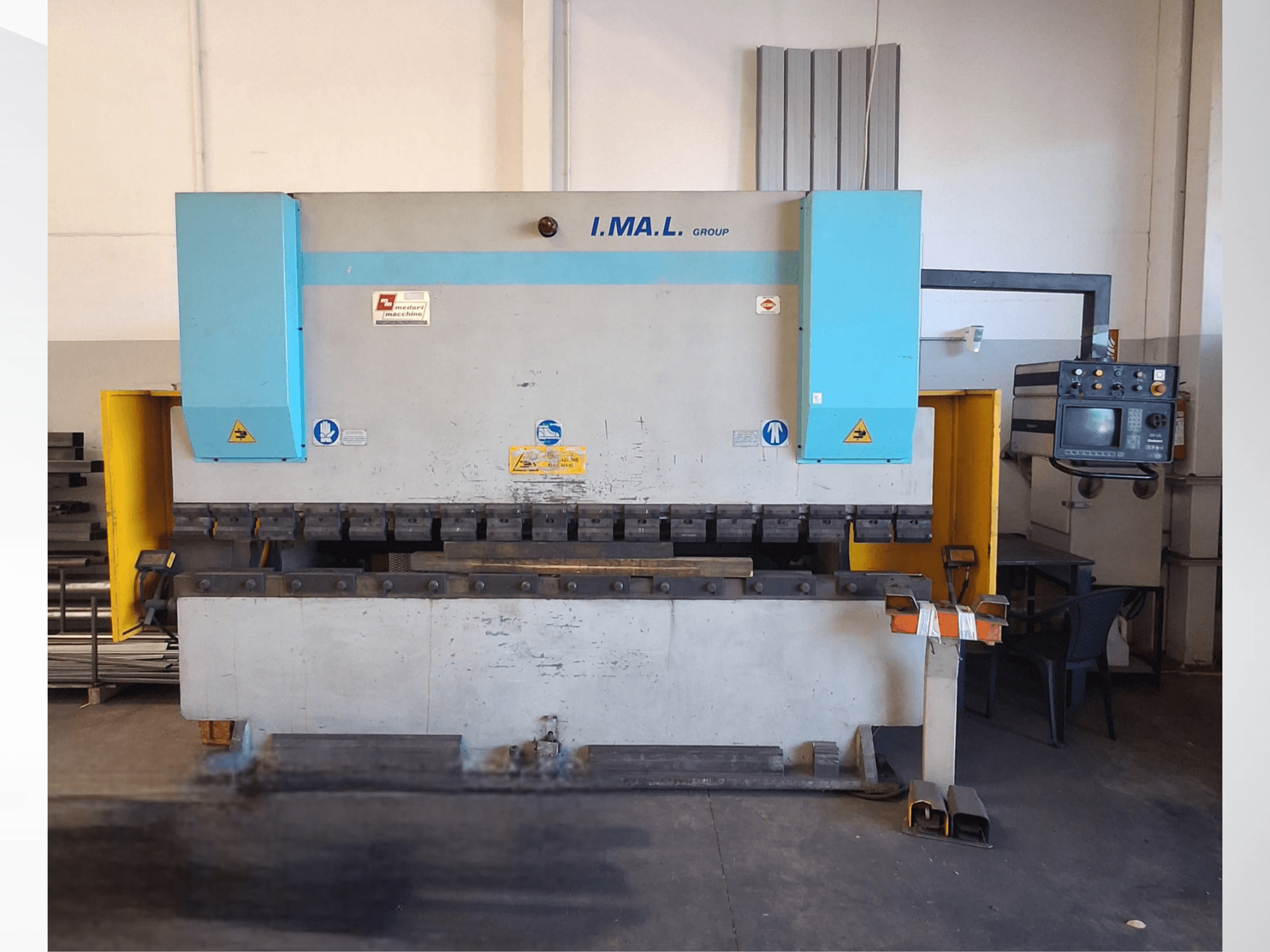 Front view of an IMAL E3A 100/33 Press Brake, featuring control panel, bending tools, and safety signage.