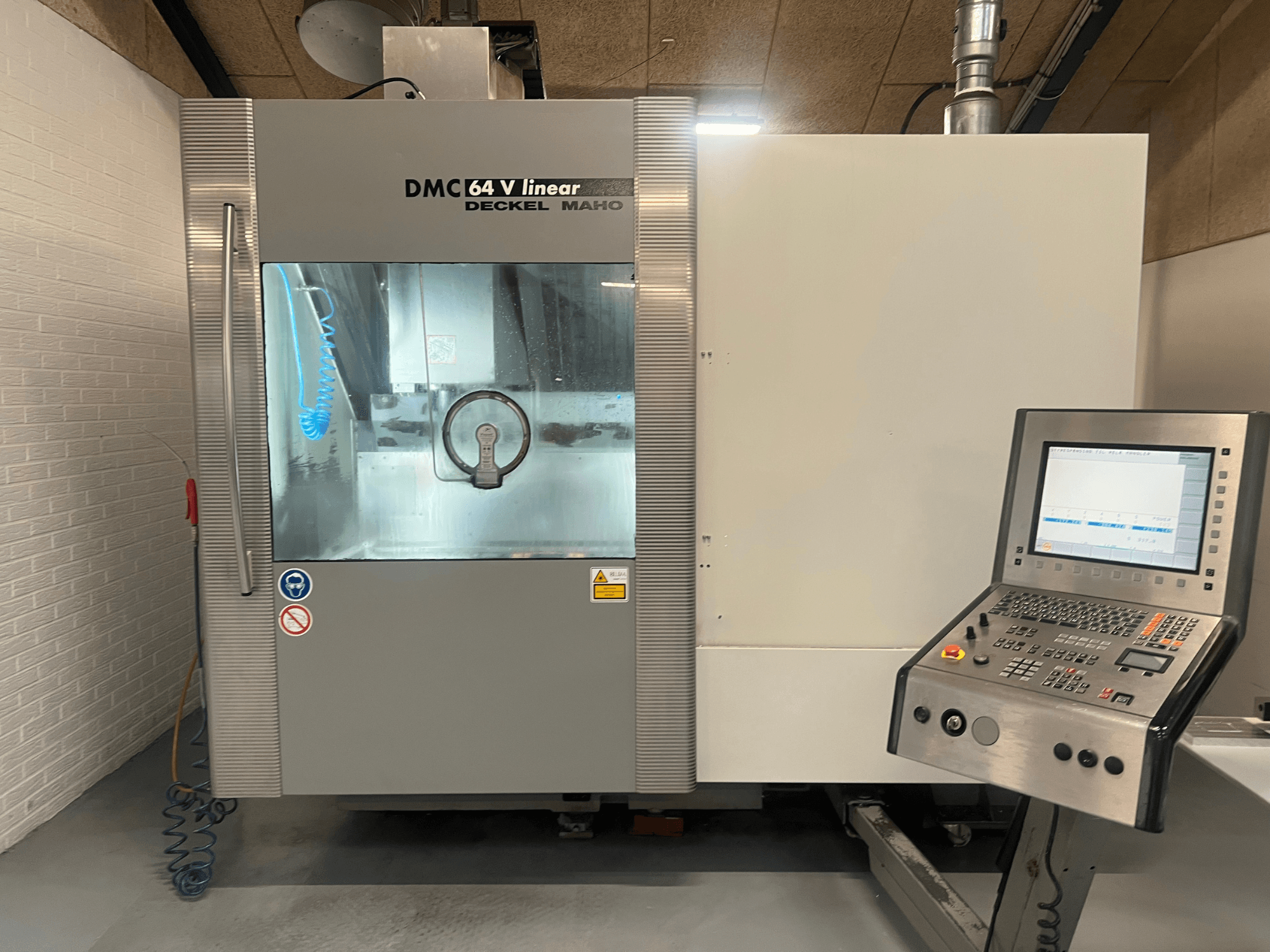 DMC 64 V Linear by Deckel Maho, front view of CNC machining center with control panel and coolant nozzle visible.