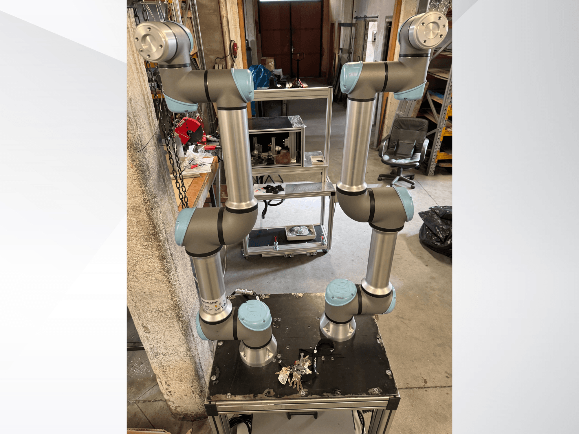 Universal Robots UR5e robot arm shown from a front view, featuring six joints with gray and blue sections, mounted on a black platform.