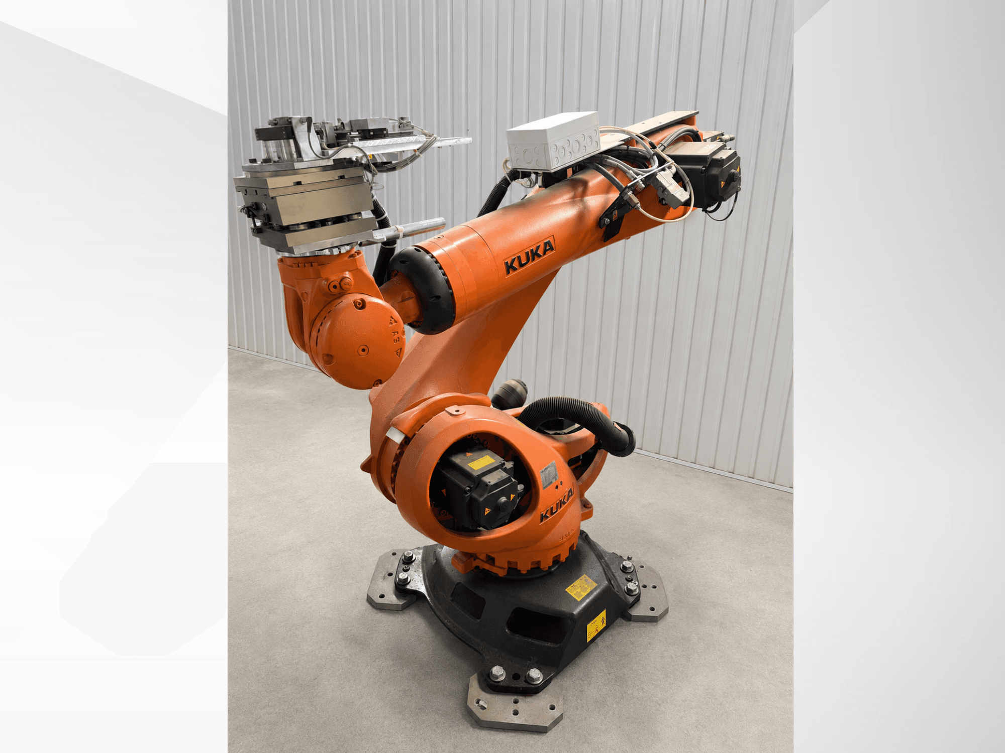 KUKA KR 90 R3100 extra robot arm in orange, side view, showcasing joints, controller, and tooling attachment on the end effector.