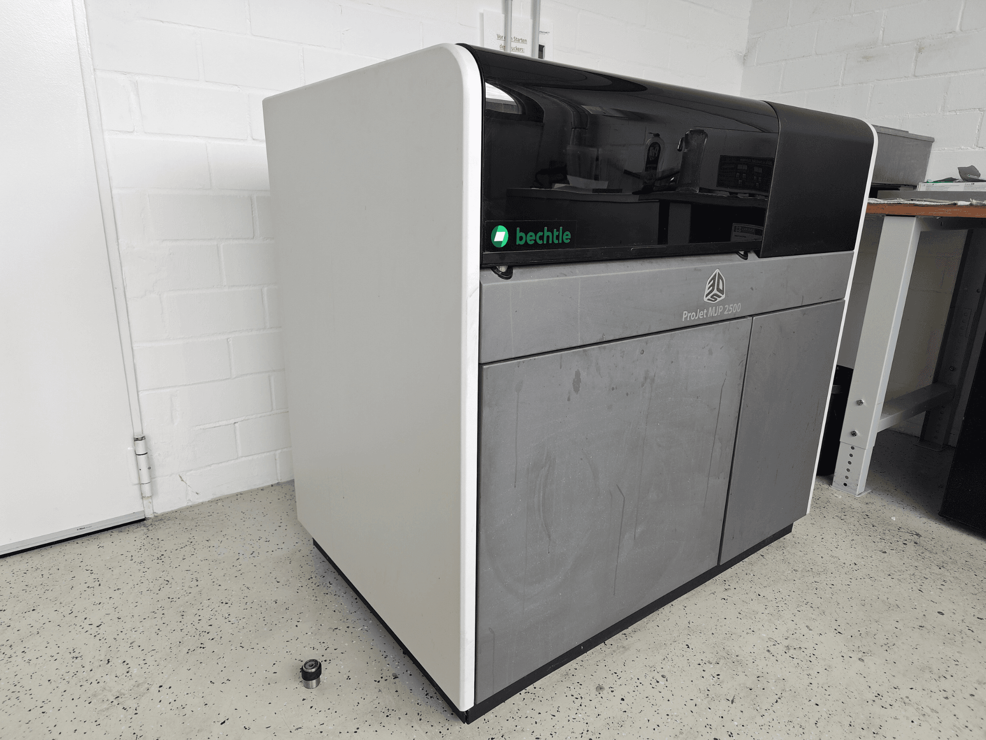3D Systems ProJet MJP 2500 Plus plastic printer in a front view; features a sleek design with a dark top and light body.