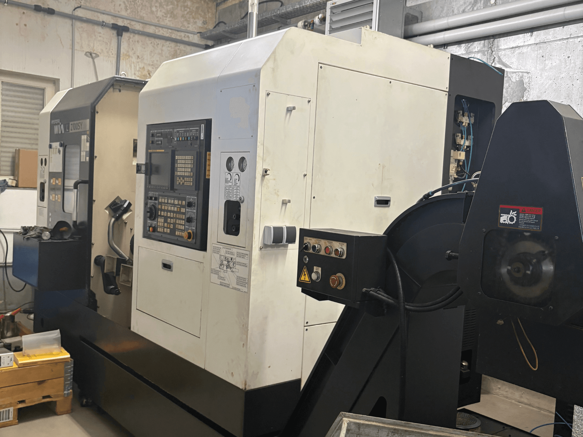 Front view of a Hyundai Wia L2100SY turn-mill centre, featuring a control panel, spindle, and operational accessories.