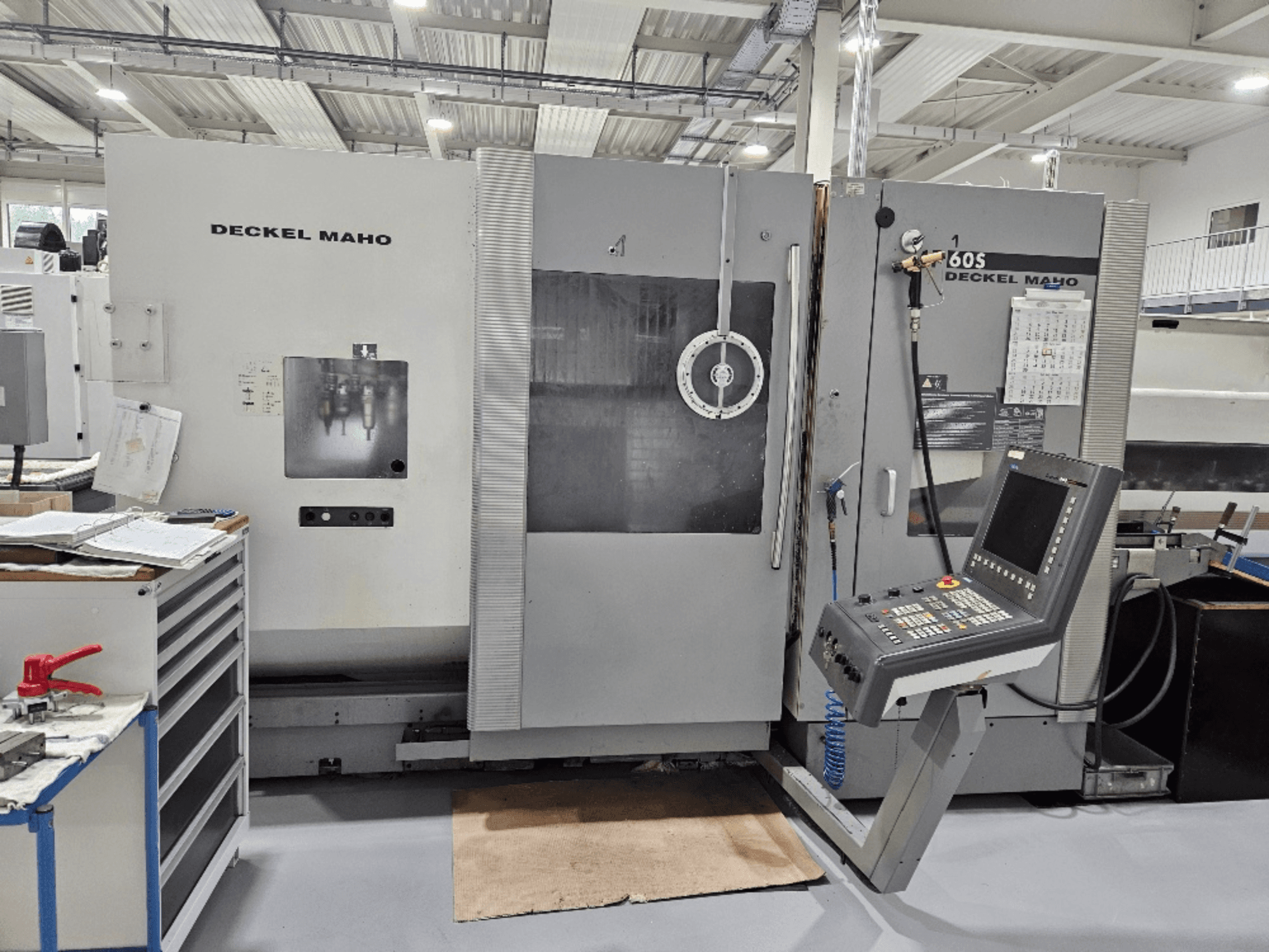 Deckel Maho 605 CNC machine with control panel and operational features, viewed from the front in a workshop setting.