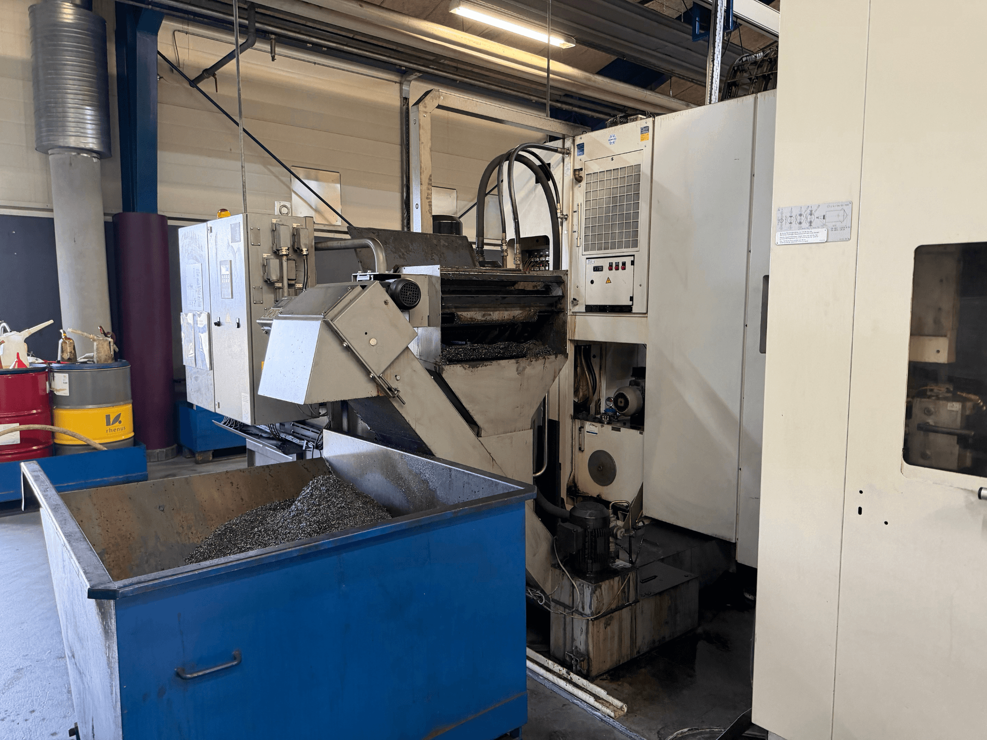 Front view of HELLER MCH 250 horizontal machining centre with metal coolant recycling bin and control panel visible.