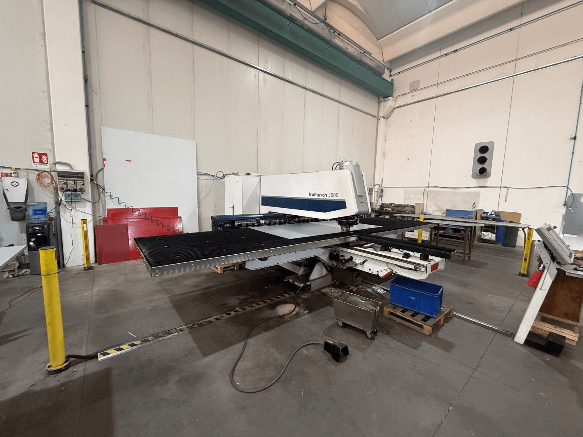CNC punching machine TRUMPF TruPunch 3000, side view, showing the punch head, large table, and surrounding workshop environment.