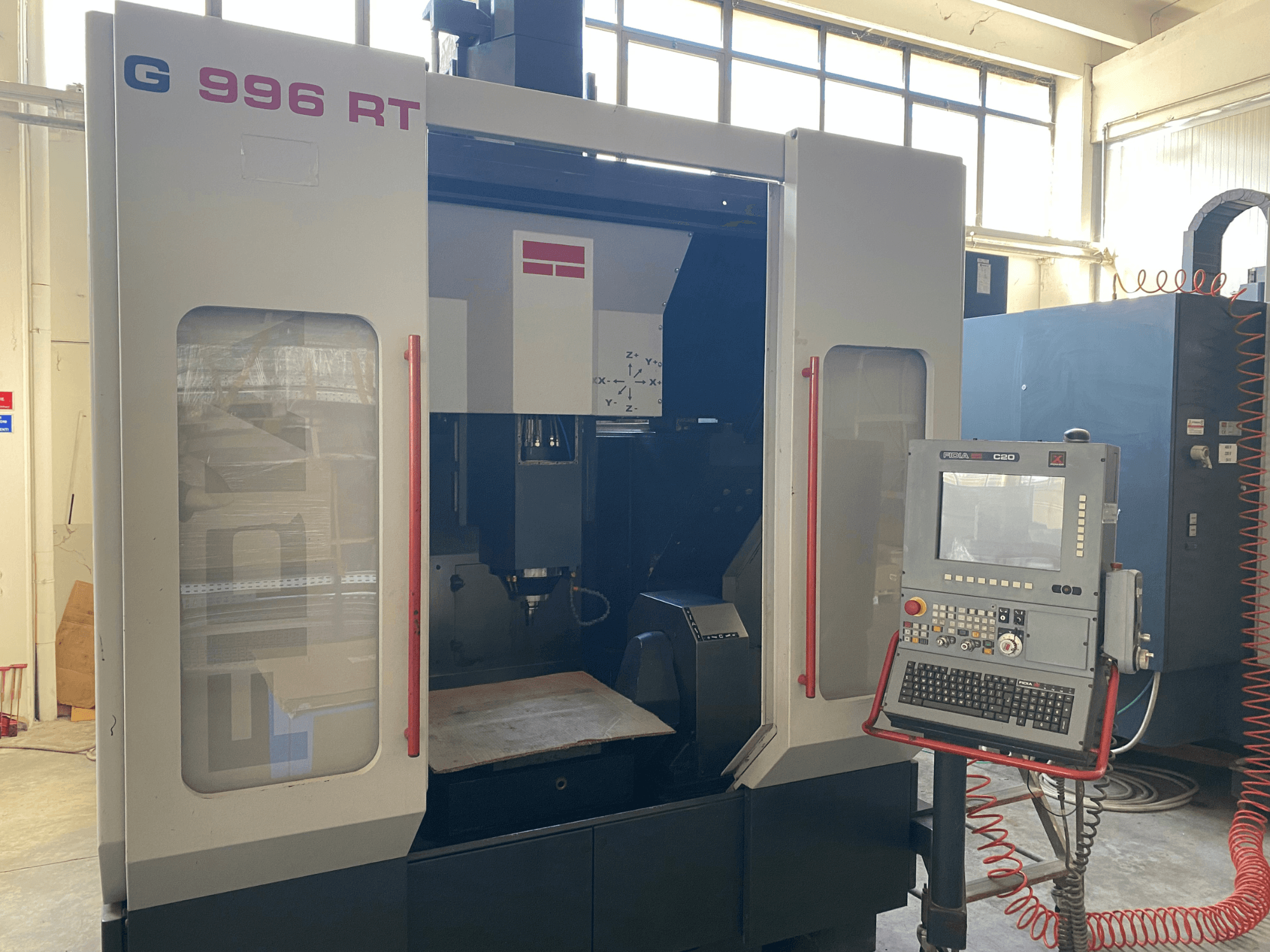 Vertical machining center Fidia G996 RT, front view with control panel, showcasing the interior workspace and operational features.
