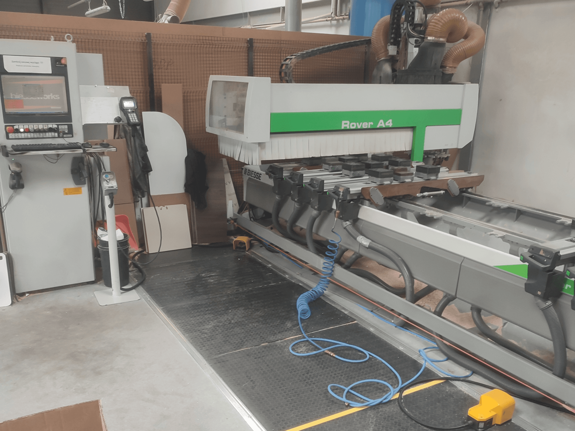 BIESSE Rover A4 CNC wood machining centre in side view, showcasing control panel, vacuum fixtures, and dust extraction system.