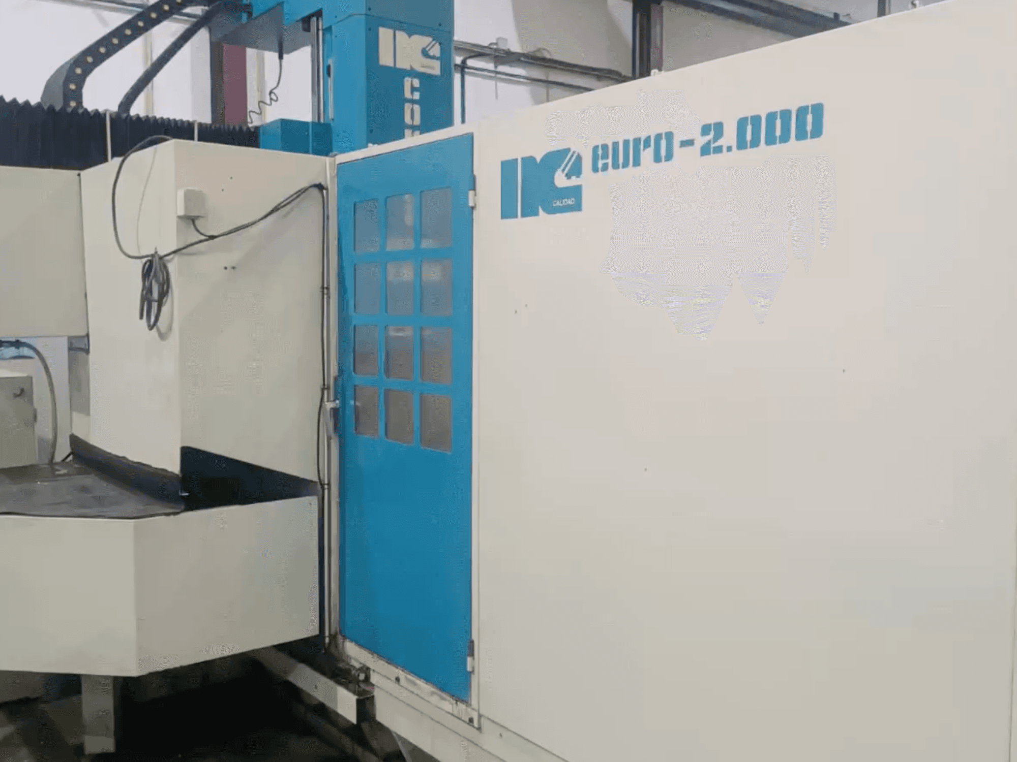 Industrial machine by IK, model Euro-2000, viewed from the front, featuring a large milling bed and control panel.