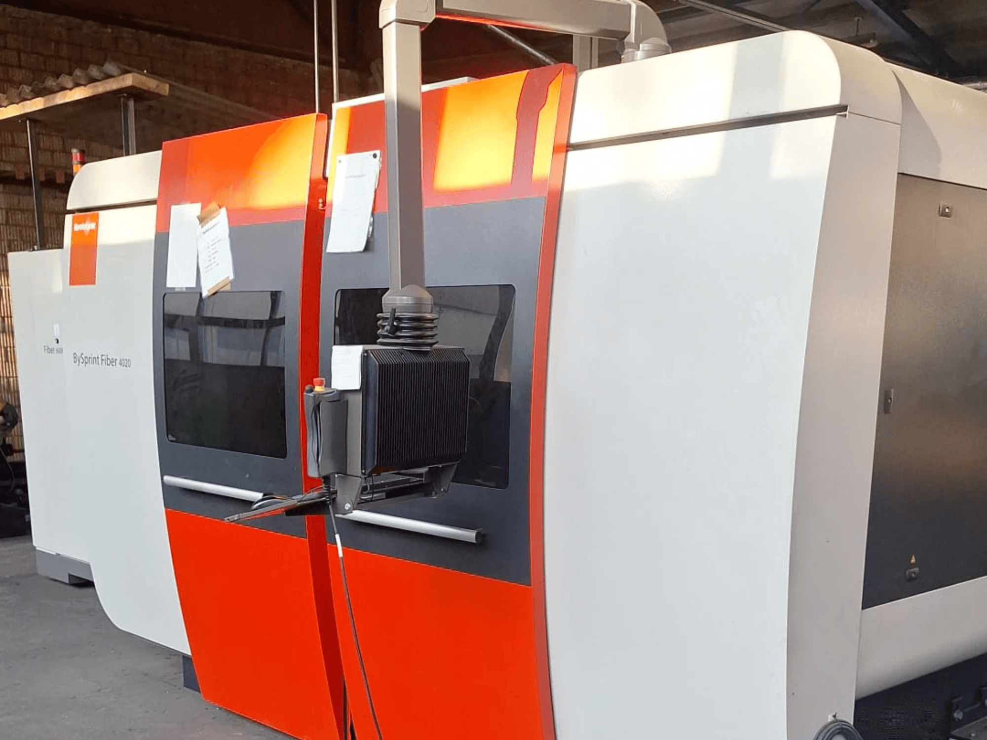 BySprint Fiber 4020 laser cutting machine, side view, with a red and white exterior, detailed control panel visible.