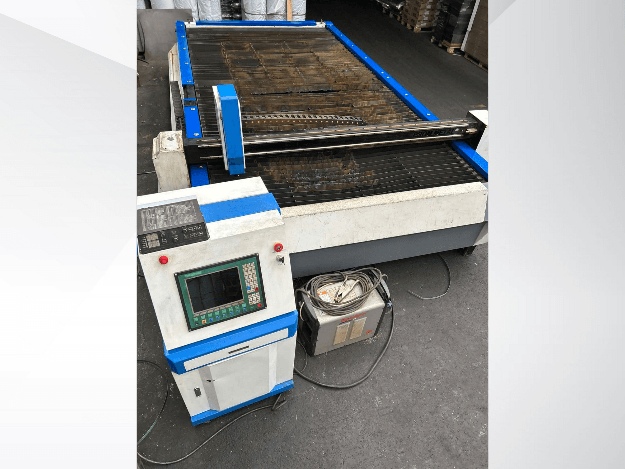 CNC plasma cutting machine with control panel, front view, featuring blue accents and cables on the floor.