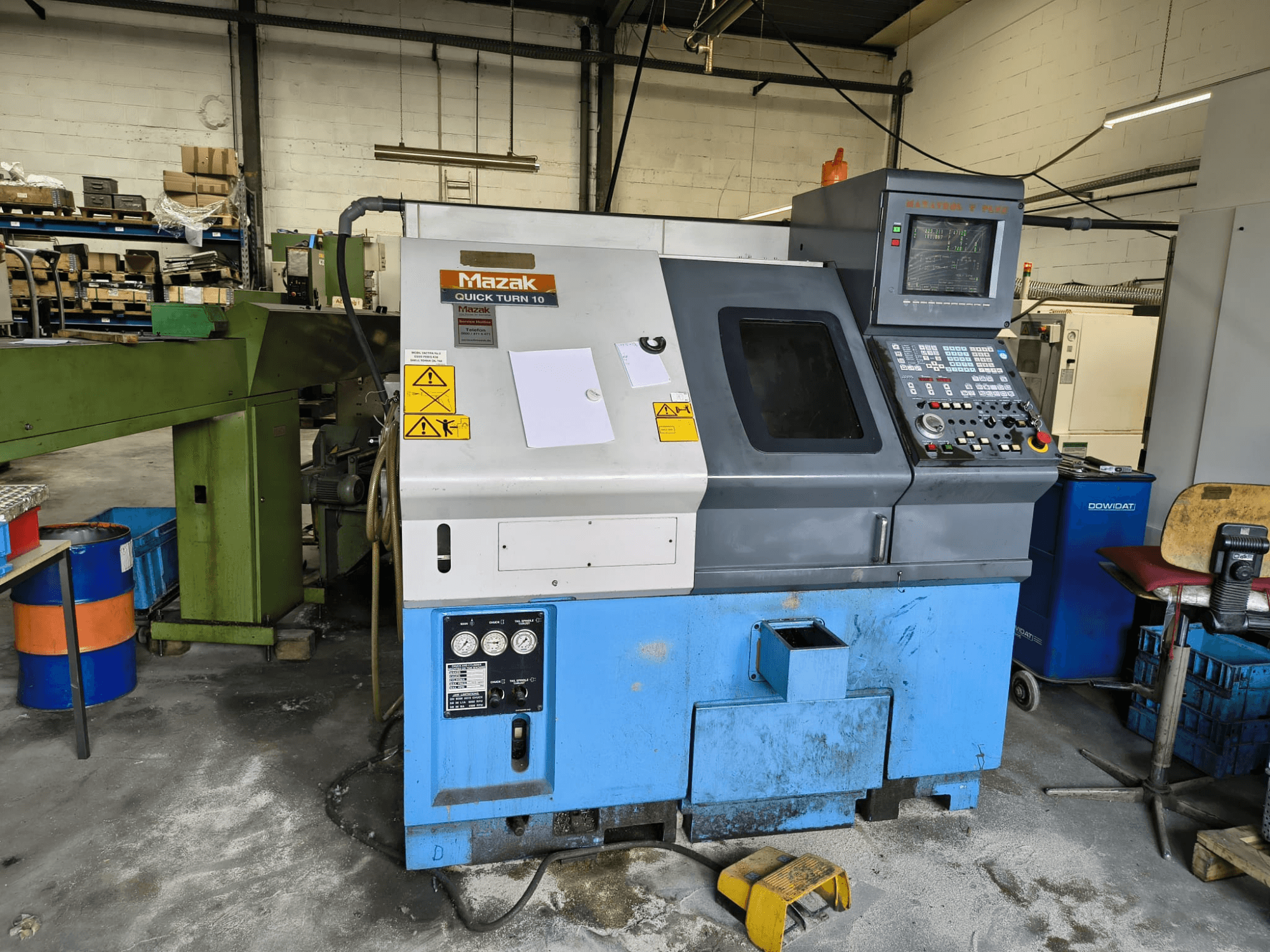 Mazak Quick Turn 10 horizontal turning machine, front view, with control panel and safety labels visible.