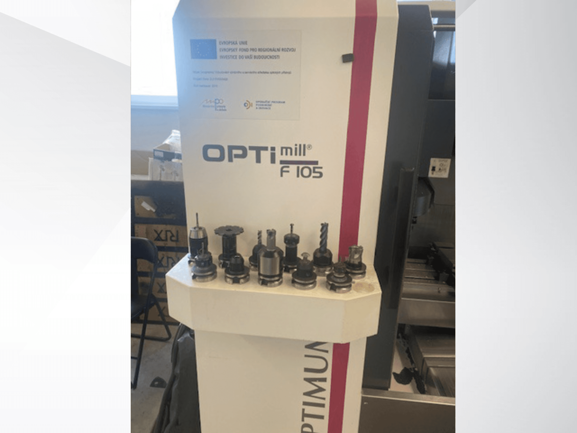 Front view of Optimum Optimill F105 vertical machining center with various attached tools displayed on the side.