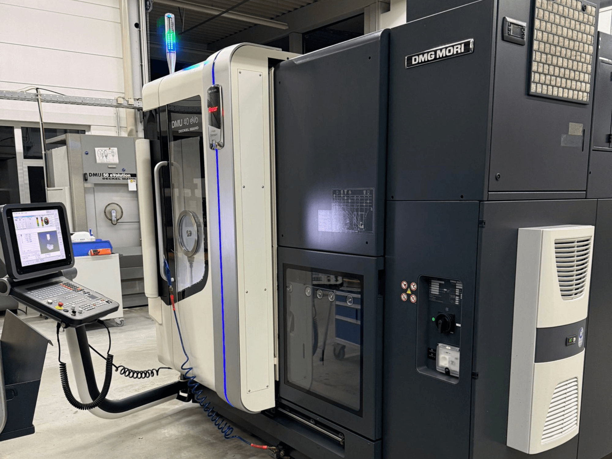 DMG MORI DMU 40 eVo machine, front view showing controls, LED indicators, and sleek design emphasizing industrial features.