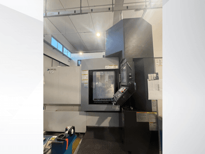 Okuma MU-6300V-L CNC machine viewed from the front, showcasing control panel and safety labels.