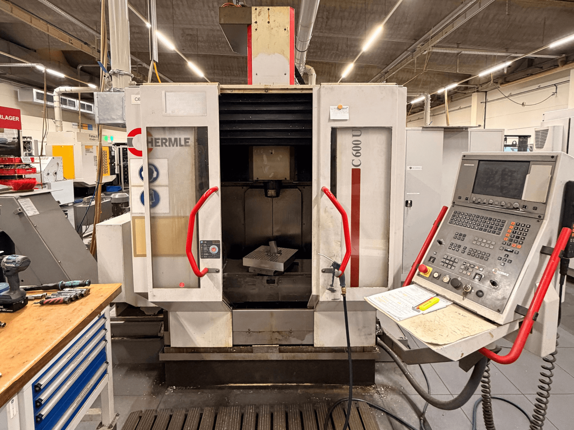 Front view of HERMLE C 600 U vertical machining center with control panel and workspace tools visible.