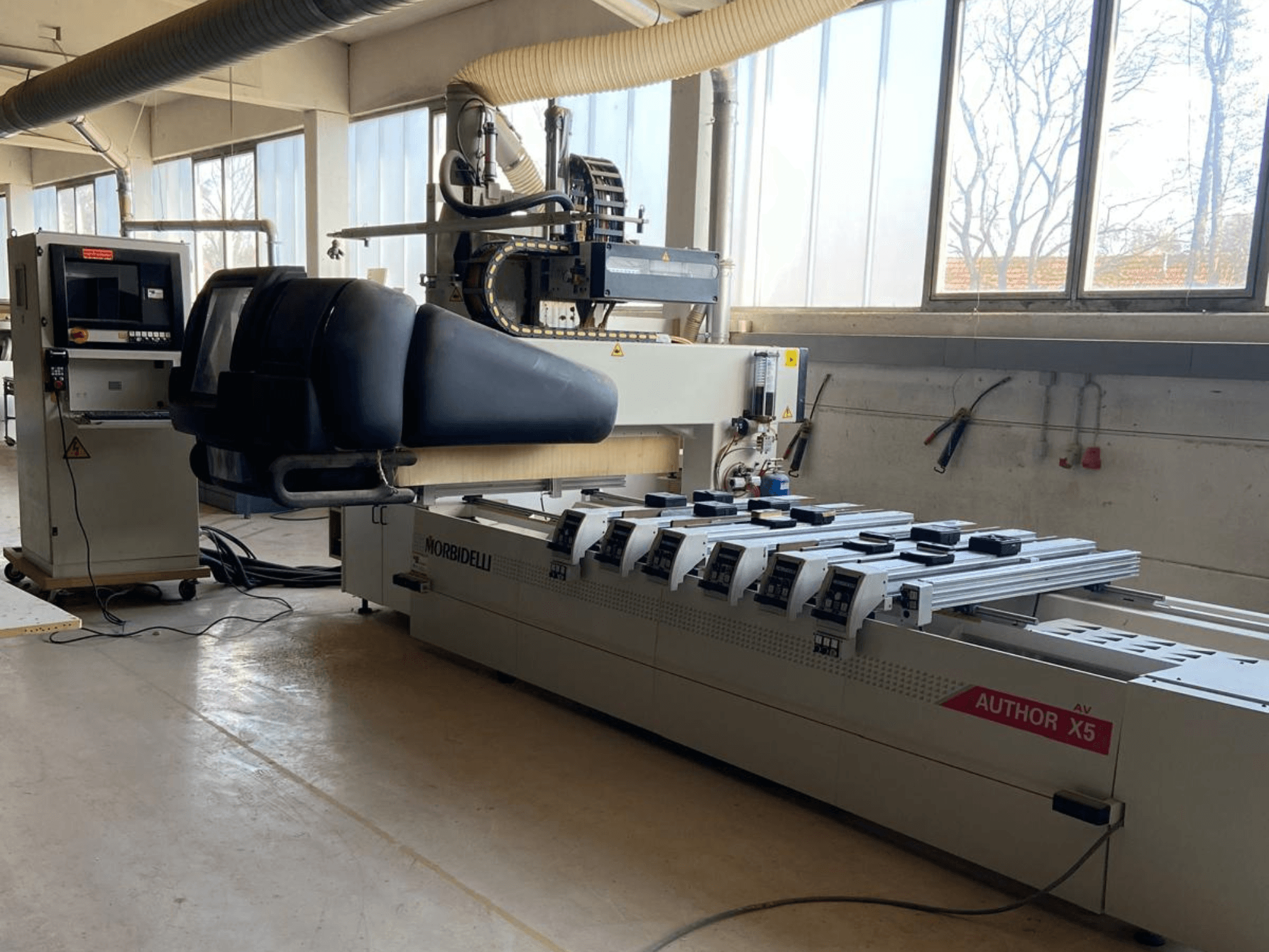 CNC Wood Machining Centre MORBIDELLI Author X5 in a workshop, showcasing control panel and machining area from a side view.