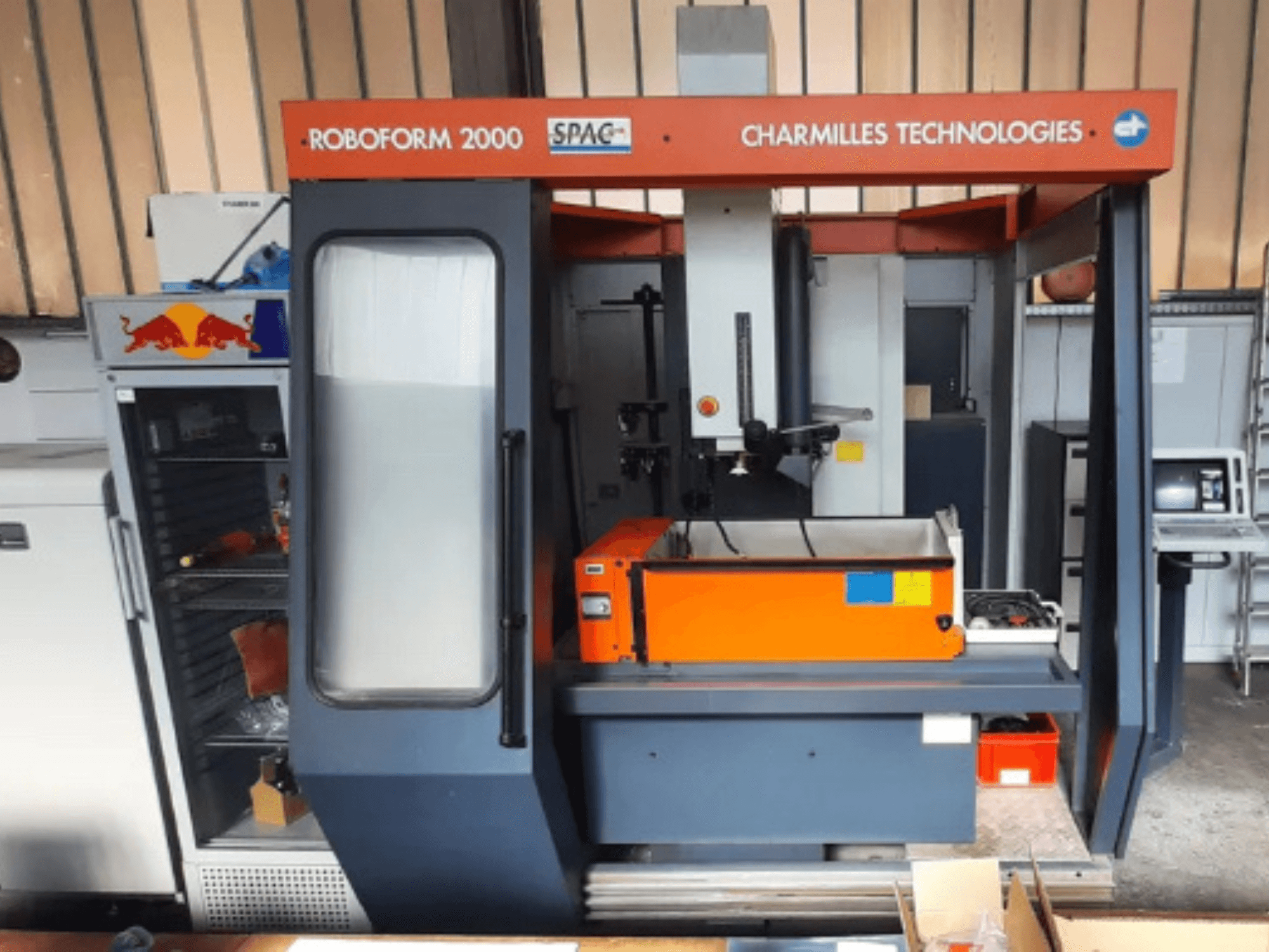 Die-sinking EDM machine CHARMILLES Roboform 2000 in a front view, featuring an orange work table and control panel.