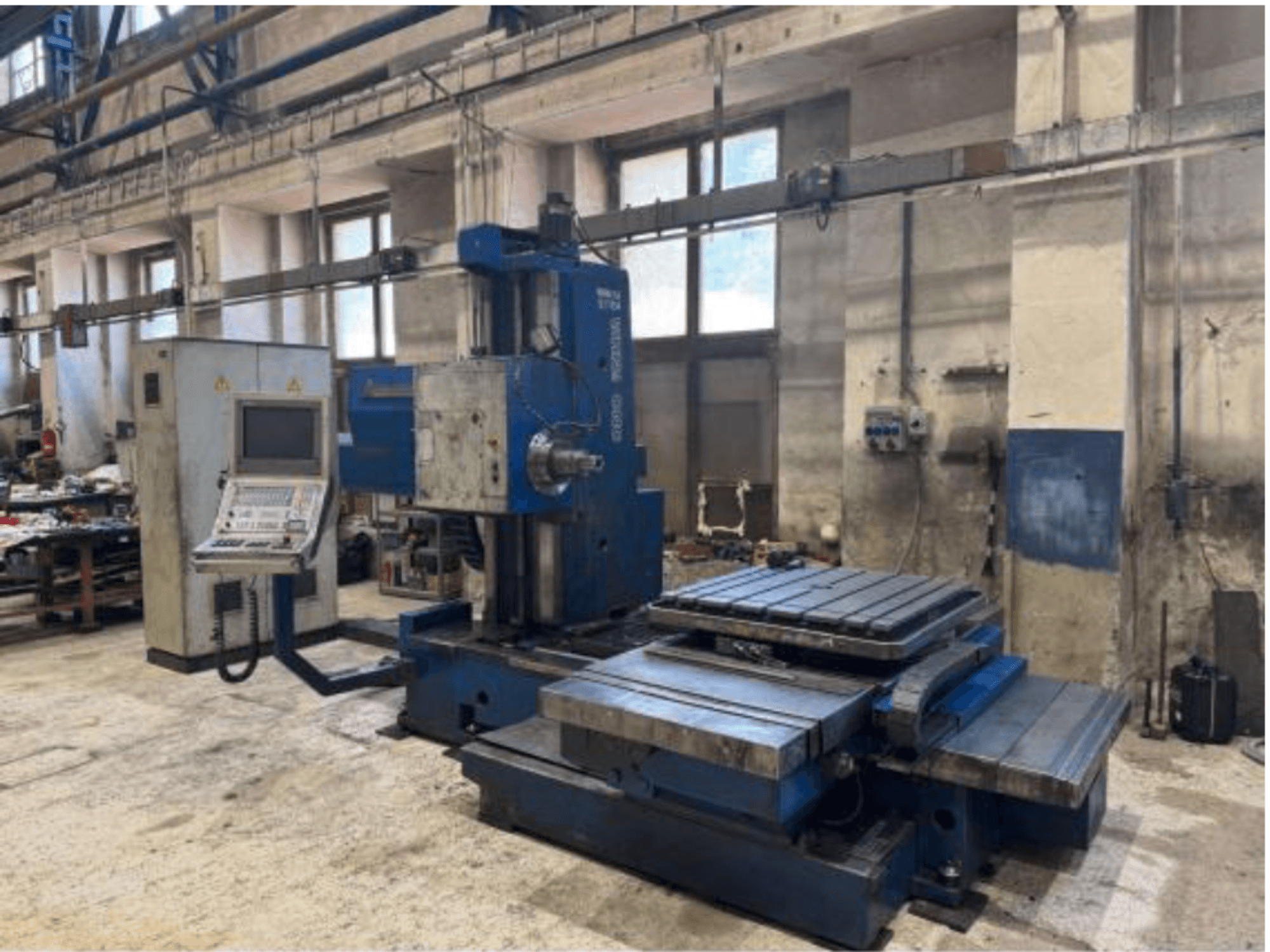 TOS WHN 9 B CNC boring machine in front view, featuring a control panel and large worktable, set in a workshop environment.