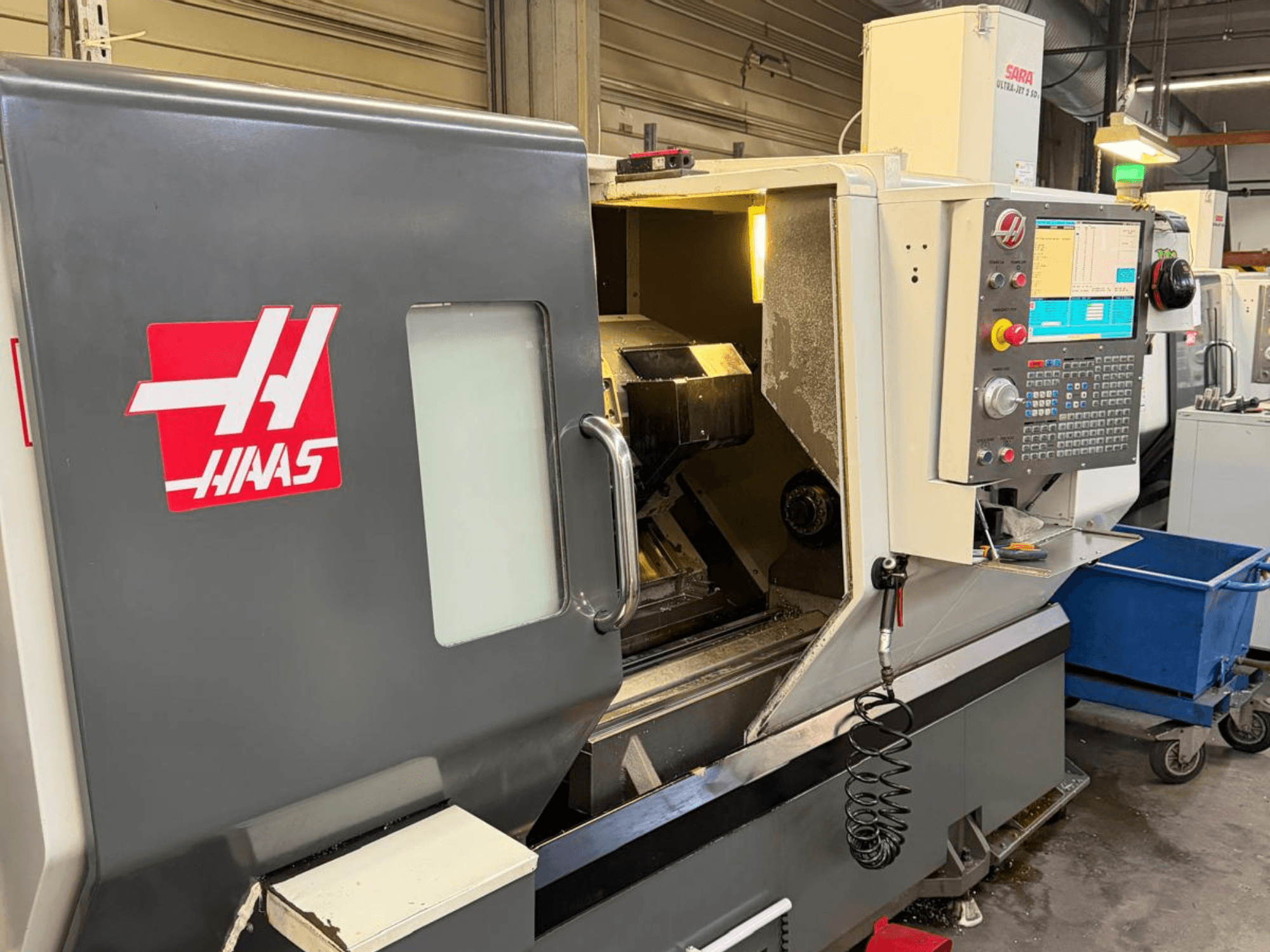 HAAS DS-30SSY horizontal turning machine, front view, with control panel and internal components visible, in workshop setting.