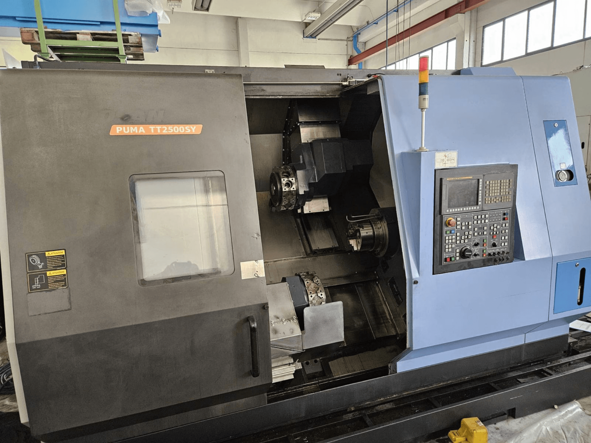 DOOSAN PUMA TT2500SY multi-spindle turning machine, front view showcasing control panel and machine interior details.