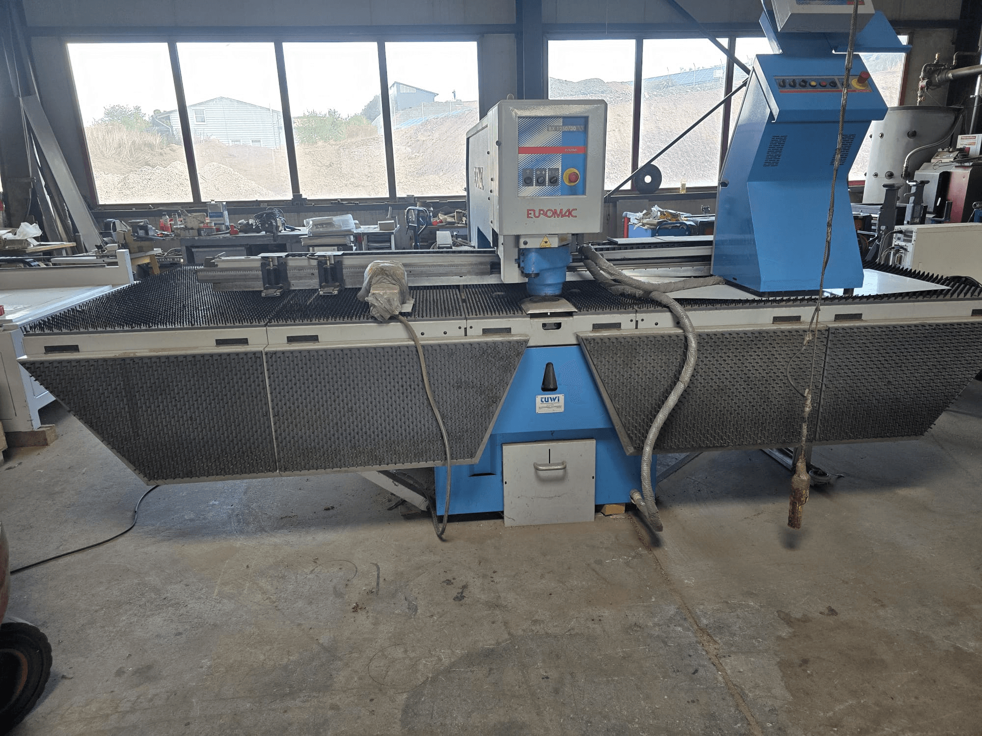 CNC Punching Machine Euromac BX 1250/30 in a workshop, side view showcasing tool controls, industrial design, and metal cutting bed.