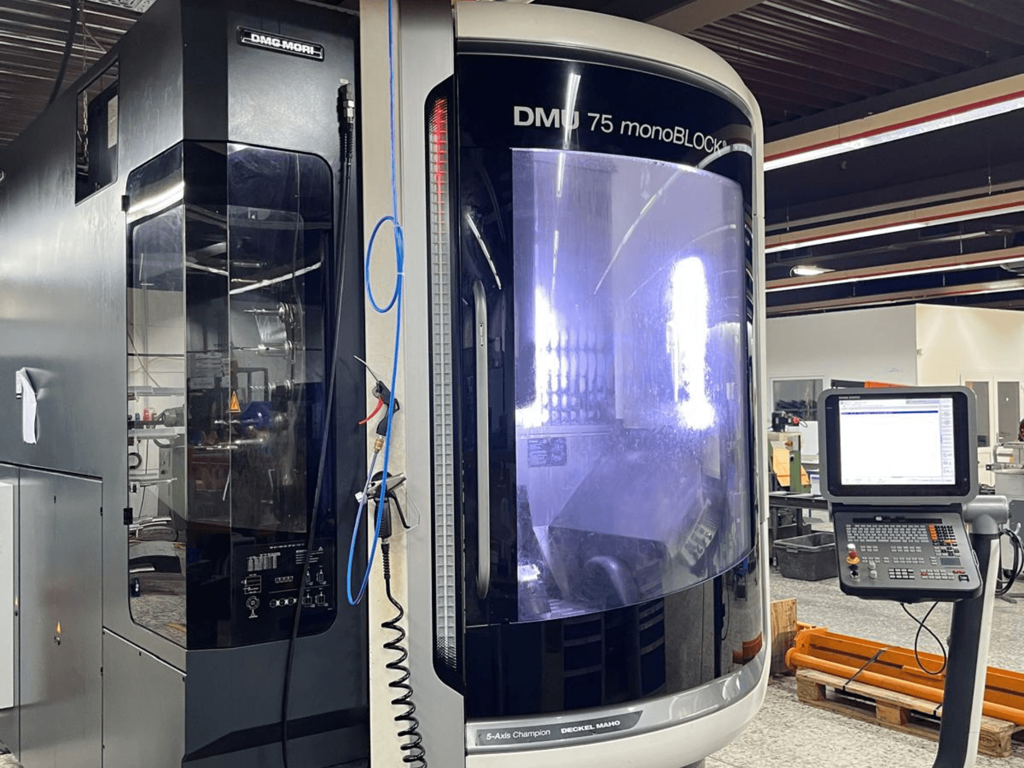 DMG MORI DMU 75 MonoBlock universal machining center, front view, displaying control panel and distinctive casing.