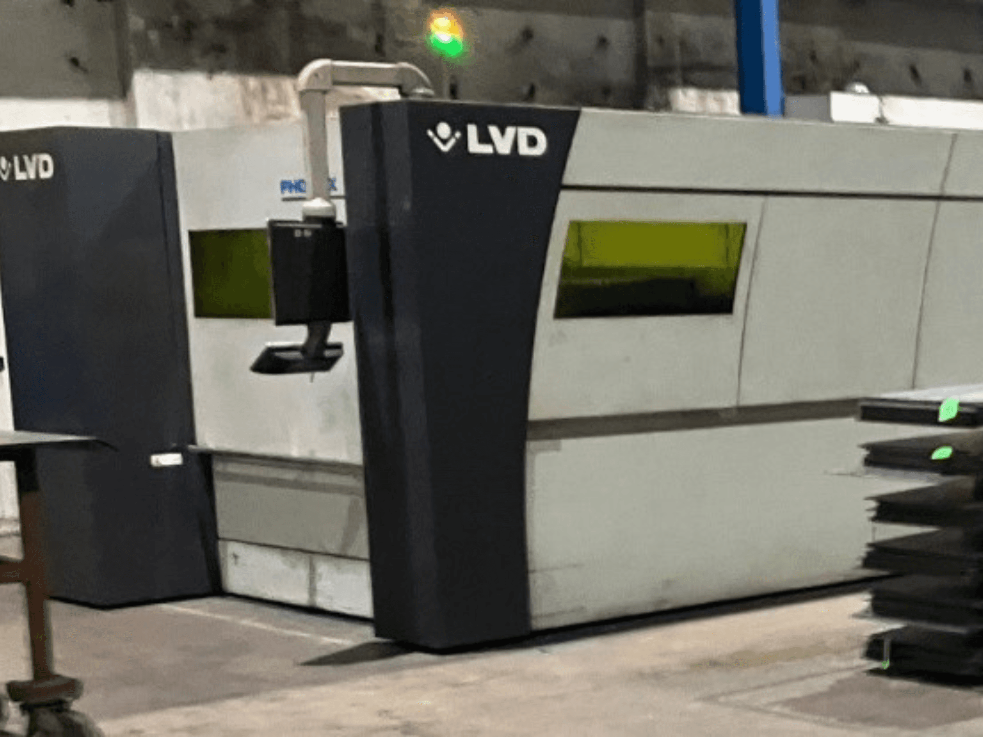 LVD industrial laser cutting machine in a factory, front view showcasing its sleek design and green operational indicator lights.