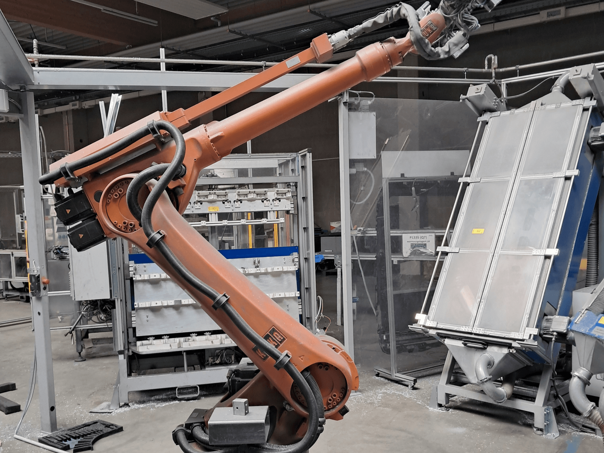 KUKA KR 30L16-2 robot arm in a factory setting, side view showing cables and mechanical components.