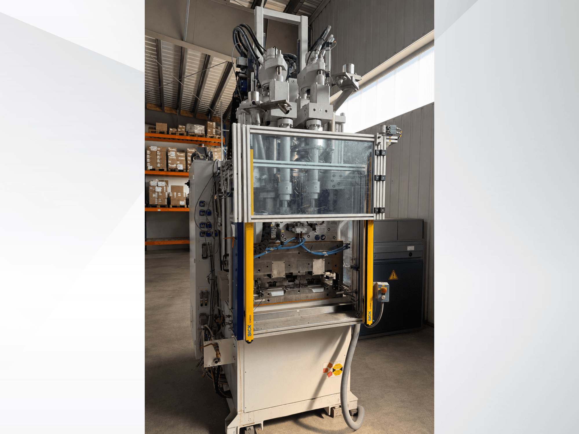 Battenfeld CM 40 vertical injection moulding machine, front view with transparent panel, showcasing control panel and injection components.